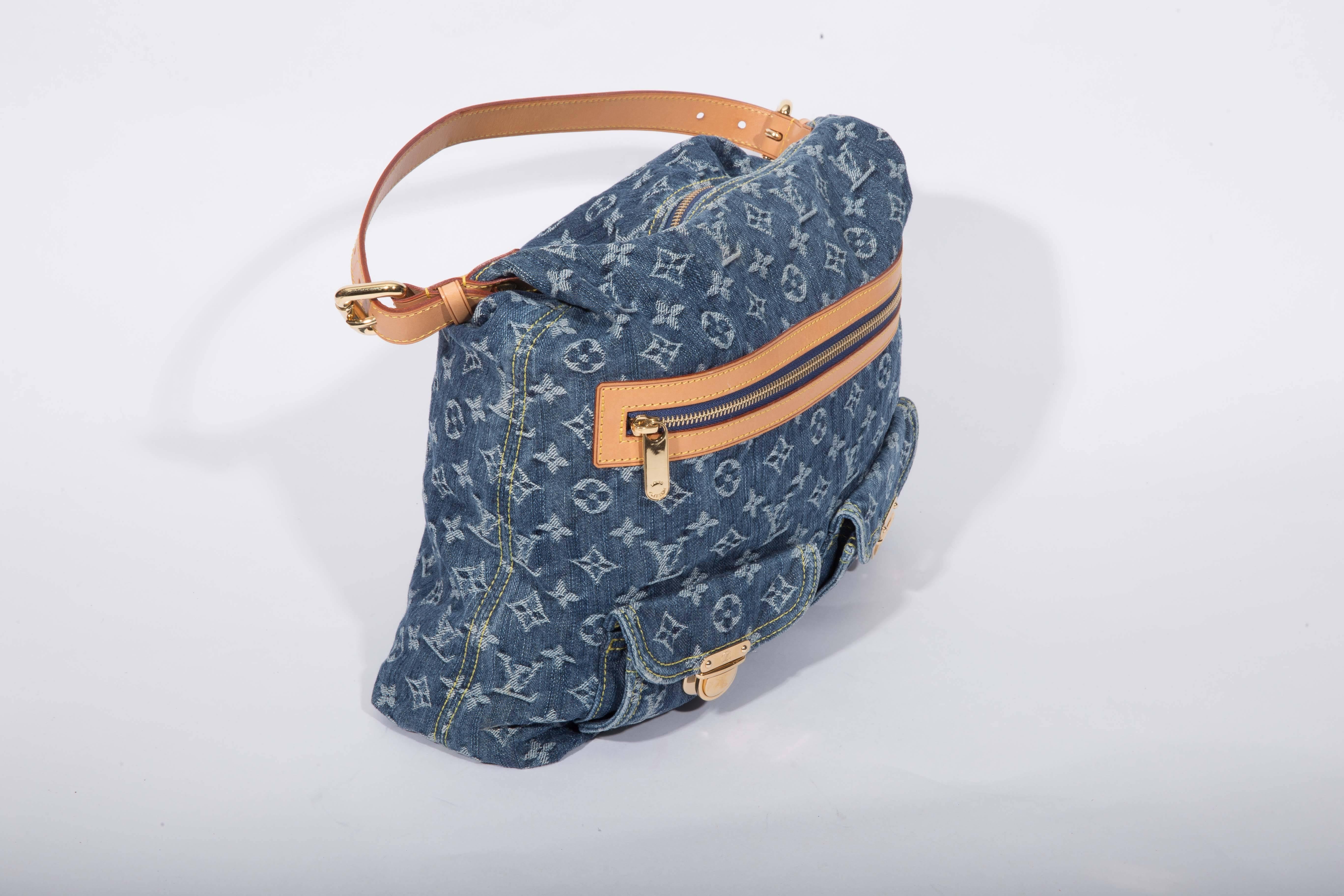 Blue monogram denim Lois Vuitton Baggy PM with brass hadware and tan vachetta leather accents throughout. Features a single flat shoulder strap, three front exterior pockets (one with zip closure and two with push lock closures). Marigold Alcantara