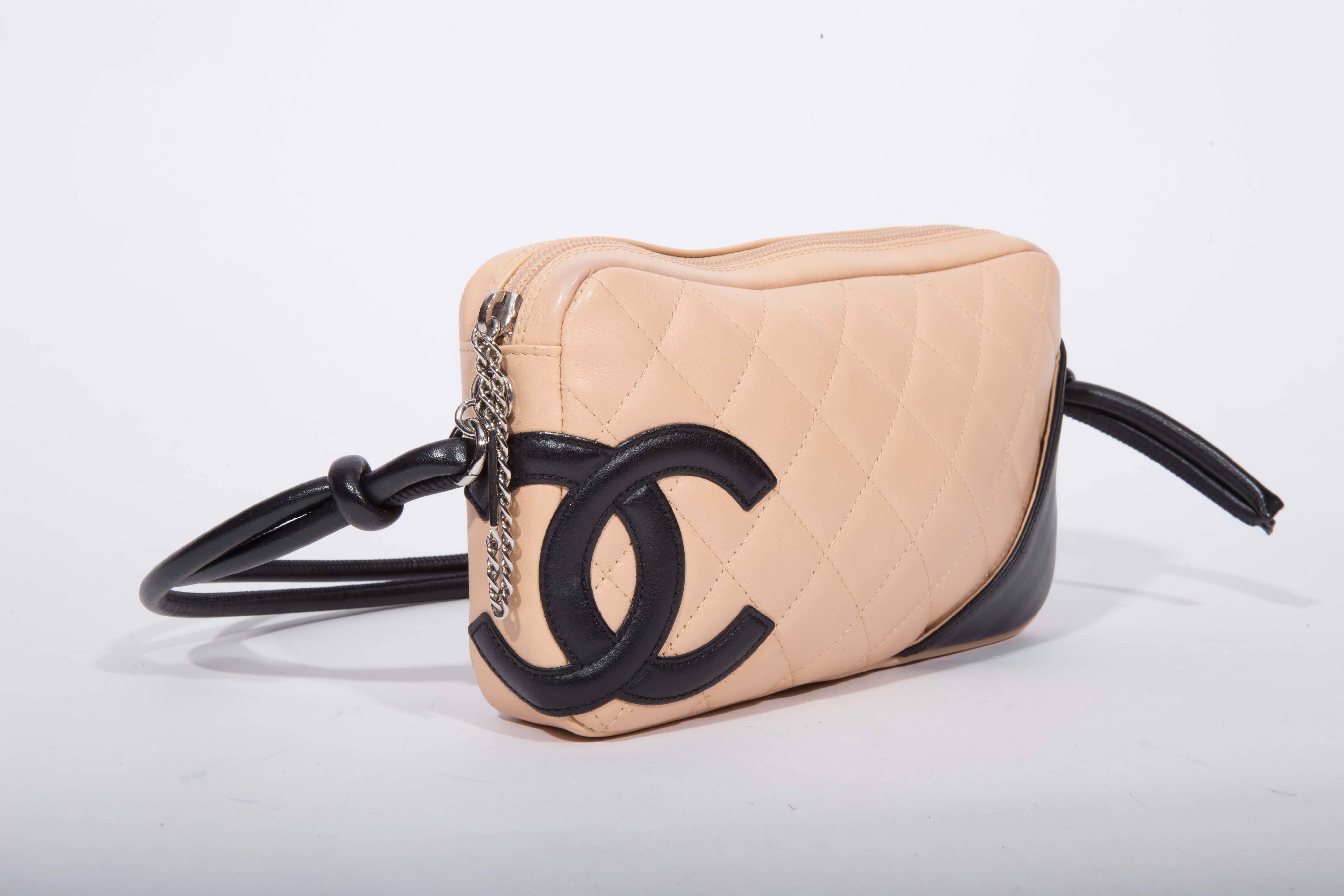 Beautiful pre-owned chic and stylish bag from the Chanel Ligne Cambon collection. 100% authentic. The gorgeous beige quilted leather bag features a stylish black leather CC logo and silvertone hardware that includes a "CHANEL" zipper pull.