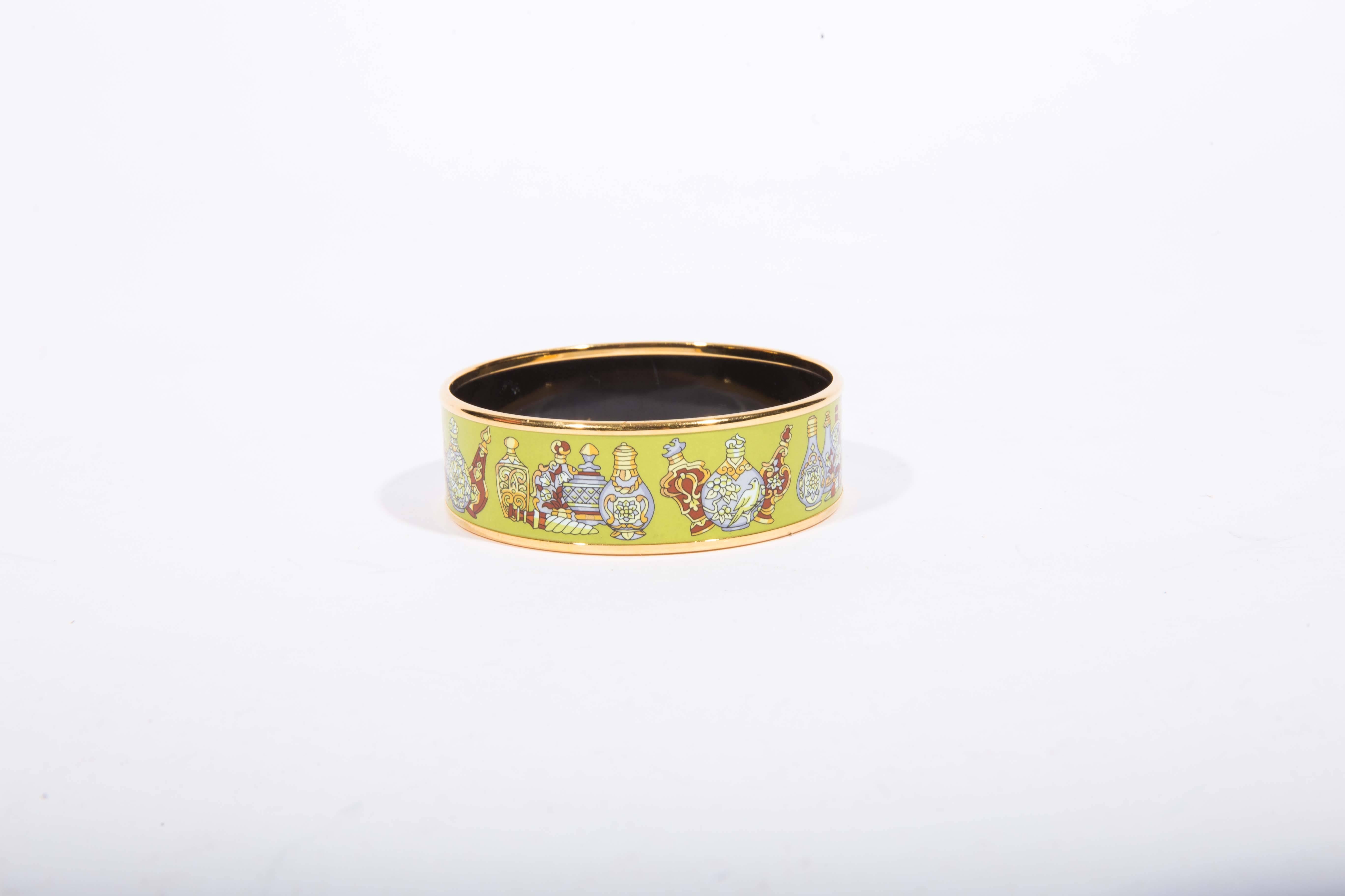 Stunning Hermes Enamel Perfume Bottle Bangle with gold tone trim. This bracelet is 3/4 inches in width with a circumference of 8 1/4 inches. The letter N denotes the year 2010. The bracelet color is predominately pistachio green with  yellow, white