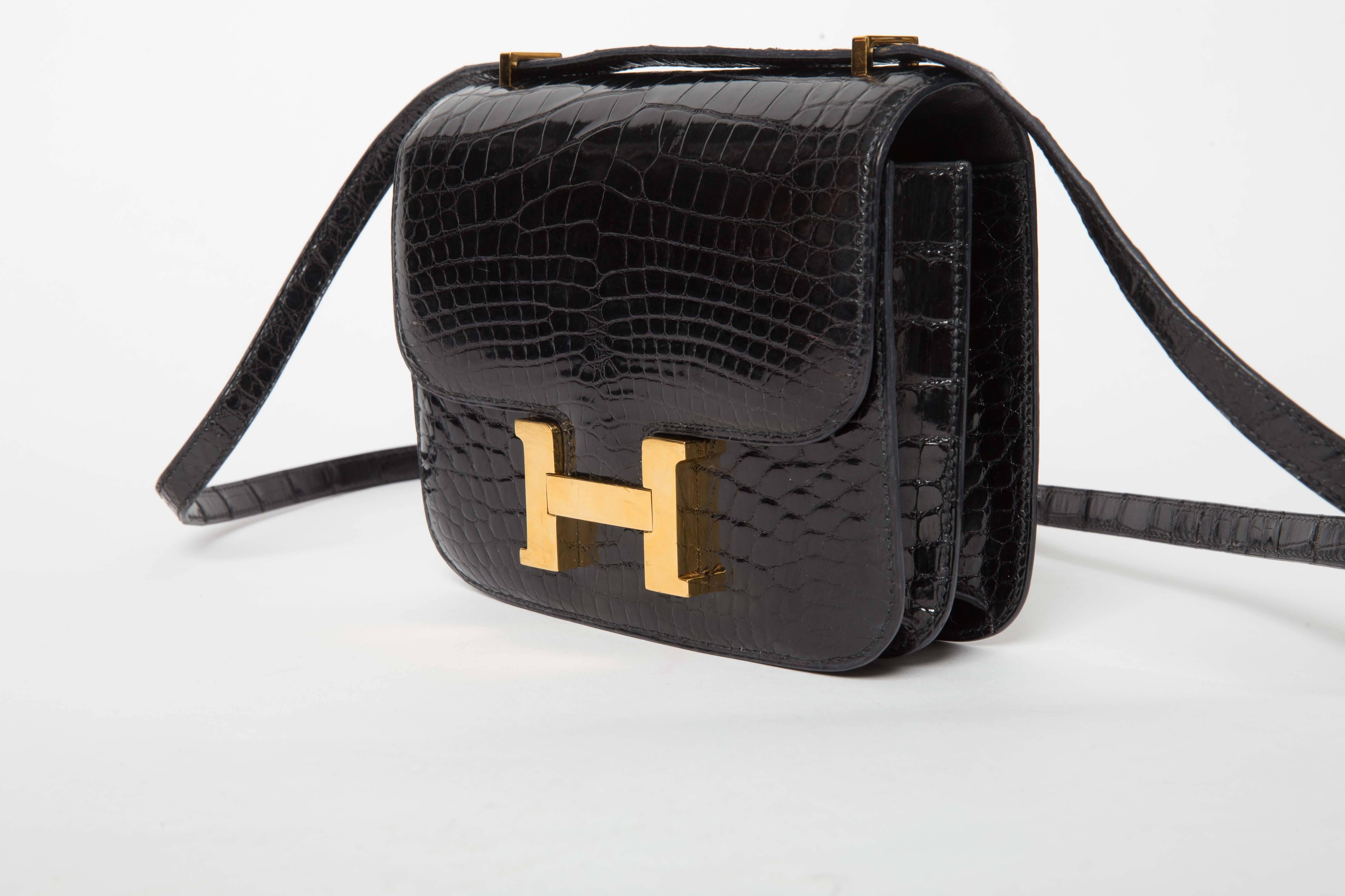 Absolutely stunning Black Baby Alligator 18 cm Hermes Constance with Gold Hardware. This iconic bag is in excellent condition. The skin is lustrous and the stitching is perfectly intact. There are scratches to the hardware consistent with age. This 