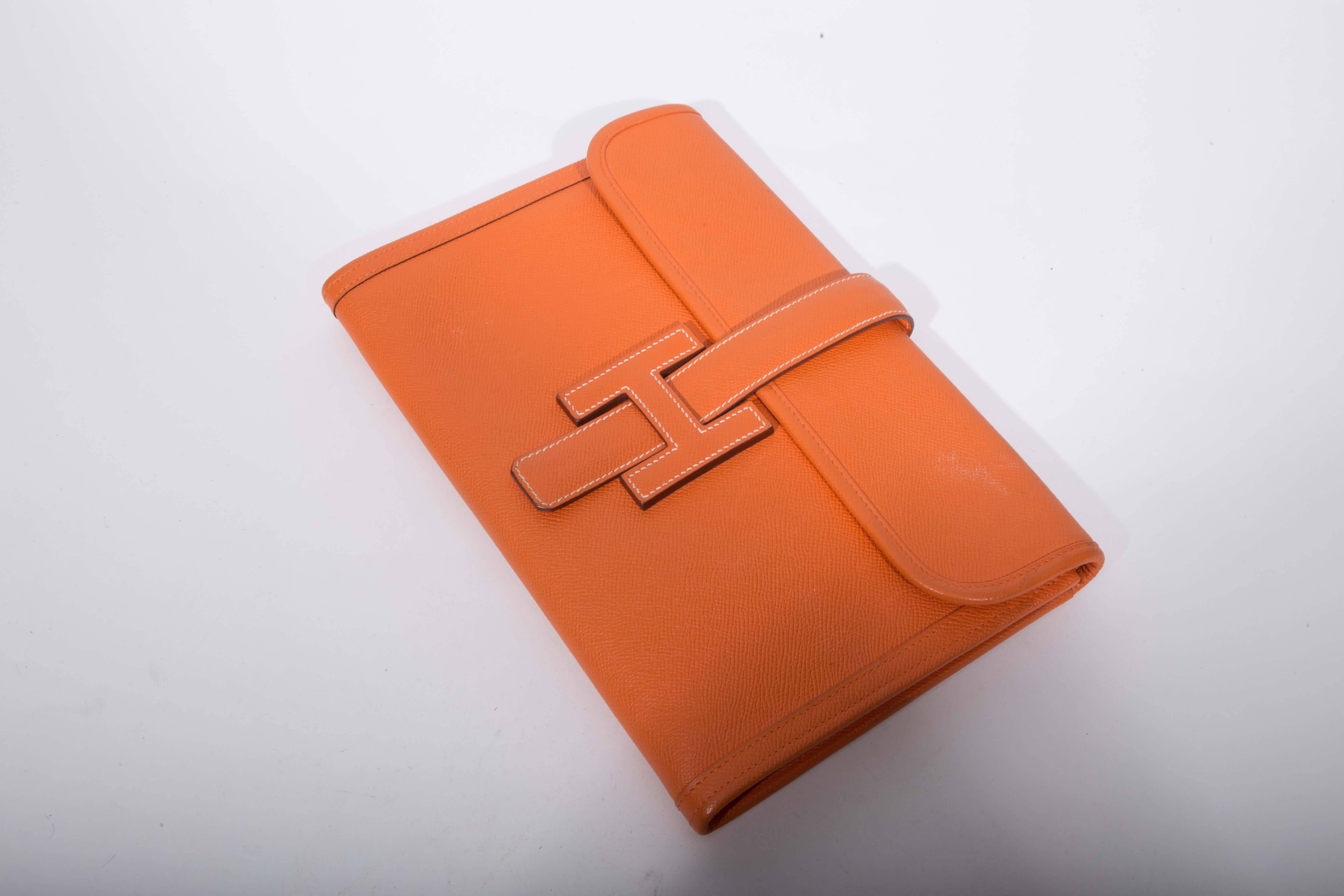 This stunning clutch in orange swift leather is the perfect choice for both day and evening. The Jige clutch closes with the iconic H logo. There are a couple of small marks to the rear of this bag. Interior is immaculate. Includes Hermes dust cover.