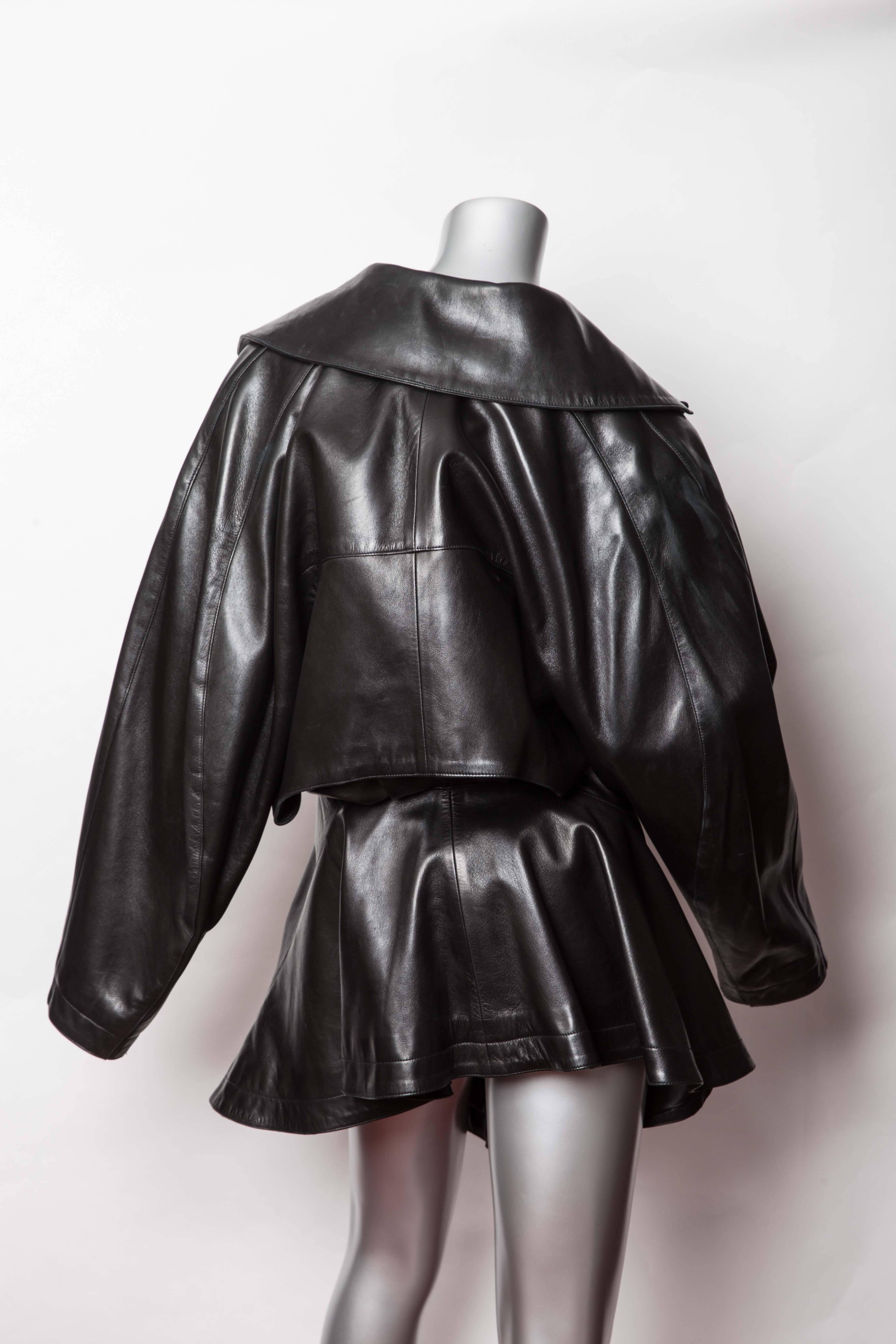 Amazing Vintage Azzedine Alaia Black Leather Jacket. This Jacket fastens at the waist with a Button. The jacket swings out from the waist and is longer in the front than the back. The back of the jacket has a cape detail. The jacket also features a