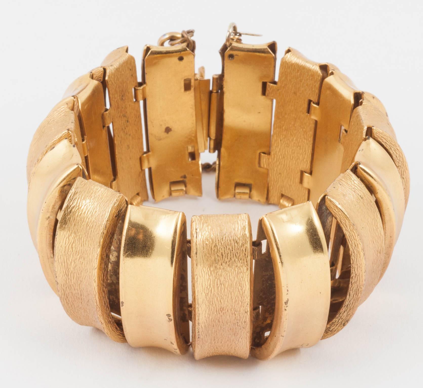 This is a lovely combination of shiny and patinated matt gilt. Miriam Haskell was known for her romantic floral and pearly designs but does have a sleeker, stronger side to which this bracelet notably belongs. It is domed and well articulated making