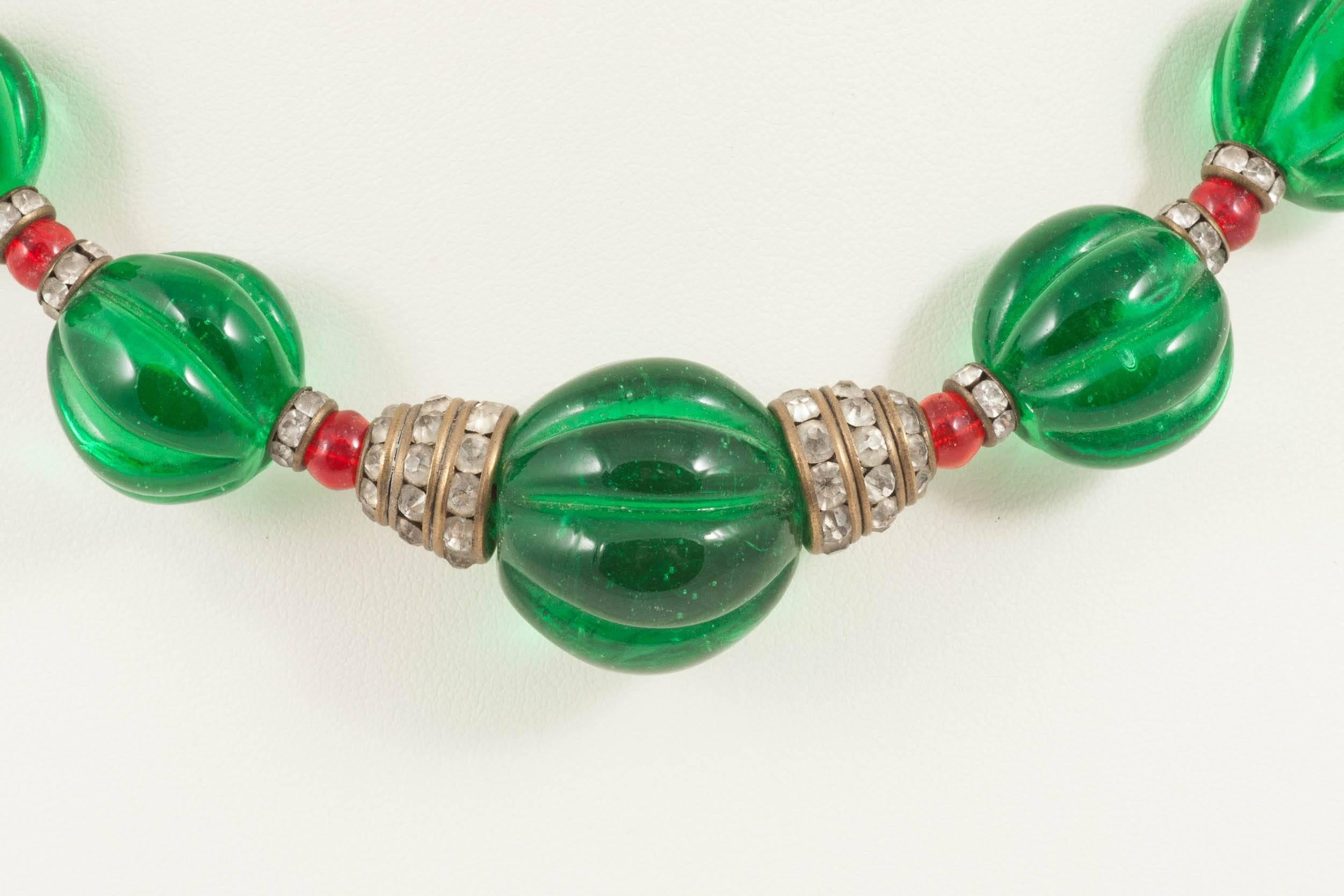 A shorter, very wearable graduated necklace made by Maison Gripoix for Chanel in the late 1930s. Poured glass melon cut emerald beads are interspersed with several rows of small poured glass ruby beads, and characteristic paste rondelles.
This