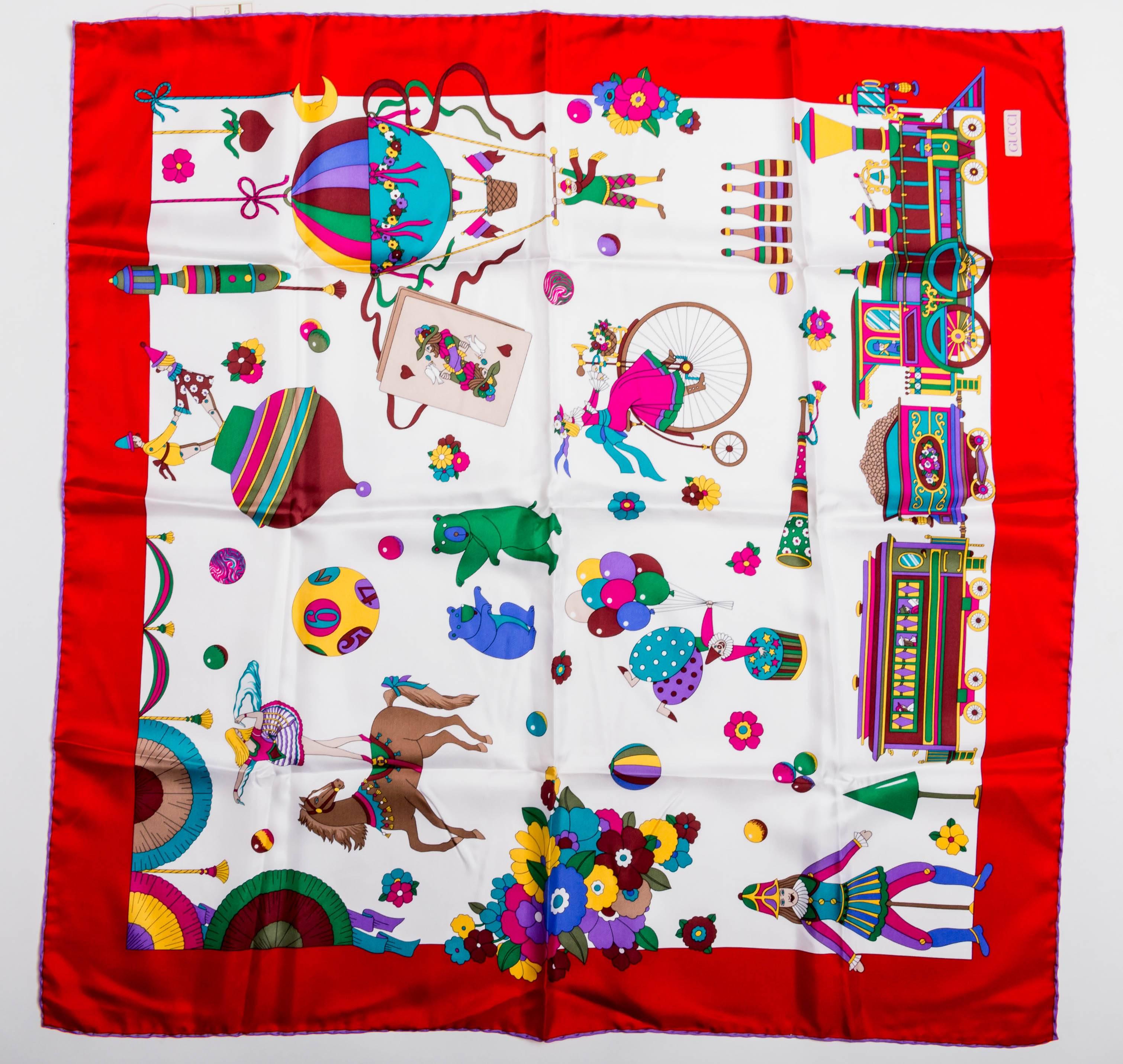 Red borders with a rolled hem in purple surround a circus themed scarf. Whimsical horses, bears and flowers in vibrant shades of blue and red on a background of white make this scarf quite outstanding.