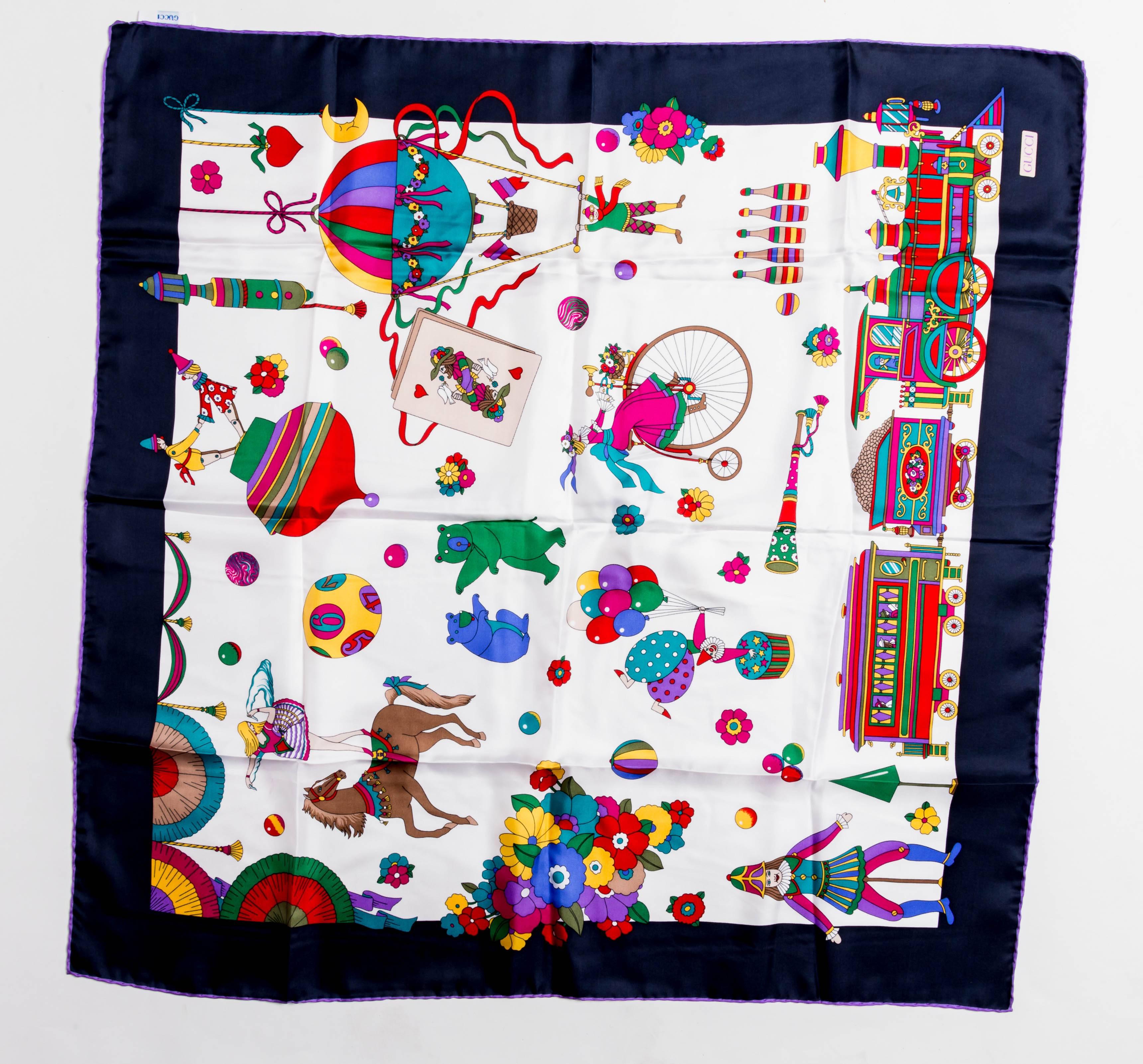 Vintage Gucci Circus Collection Scarf from the late 20th Century.
Features a navy blue border with whimsical bears, clowns and acrobats throughout. 
There is a small pink mark (lipstick?) to this otherwise impeccable silk scarf.