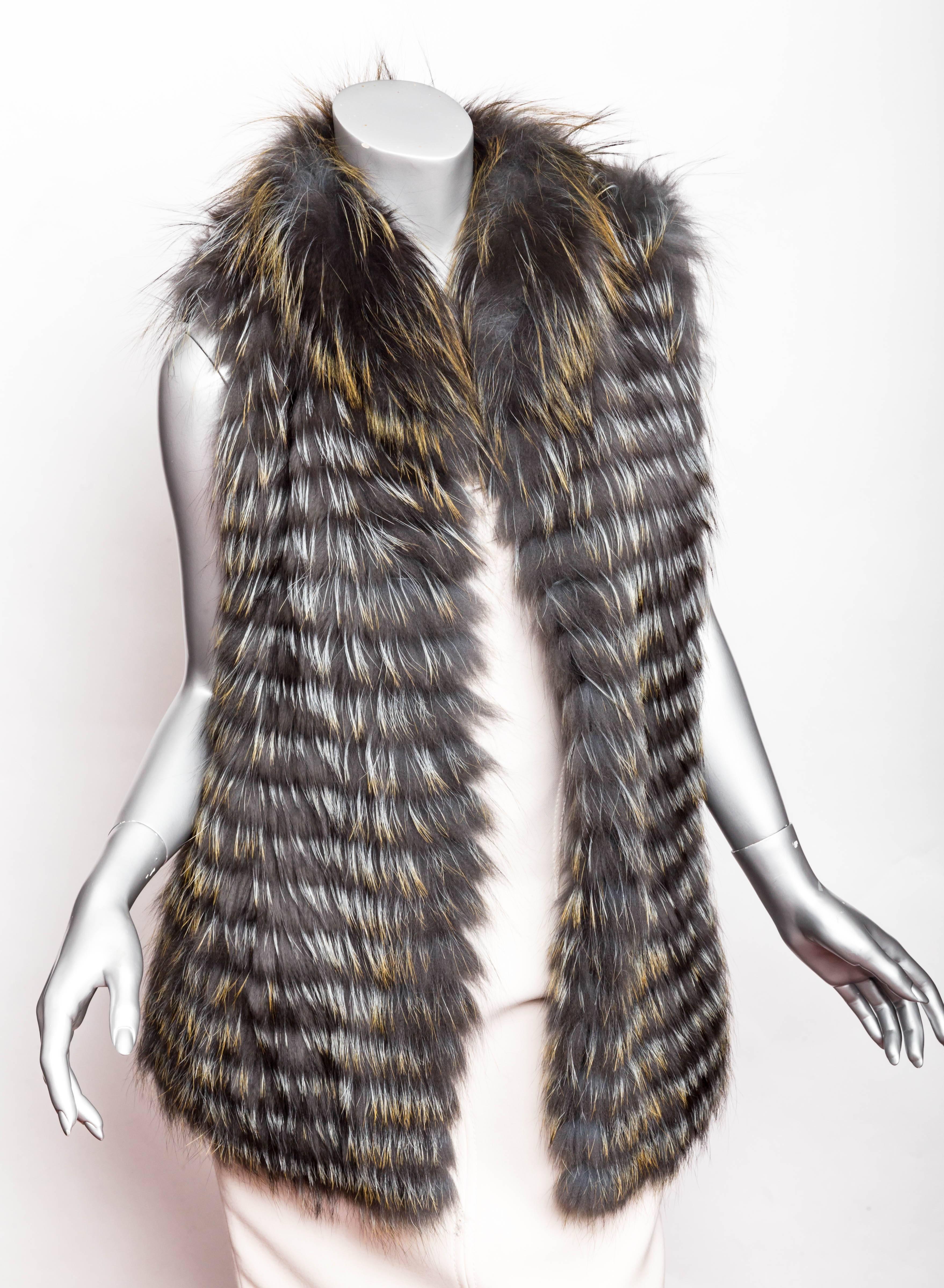This Cassin Dyed Silver Fox Fur Vest is stunning. In shades of grey with hints of silver, this vest is your perfect layering piece. One invisible hook and eye cinches this vest at the waist. Great length and a very light wearable fur vest.