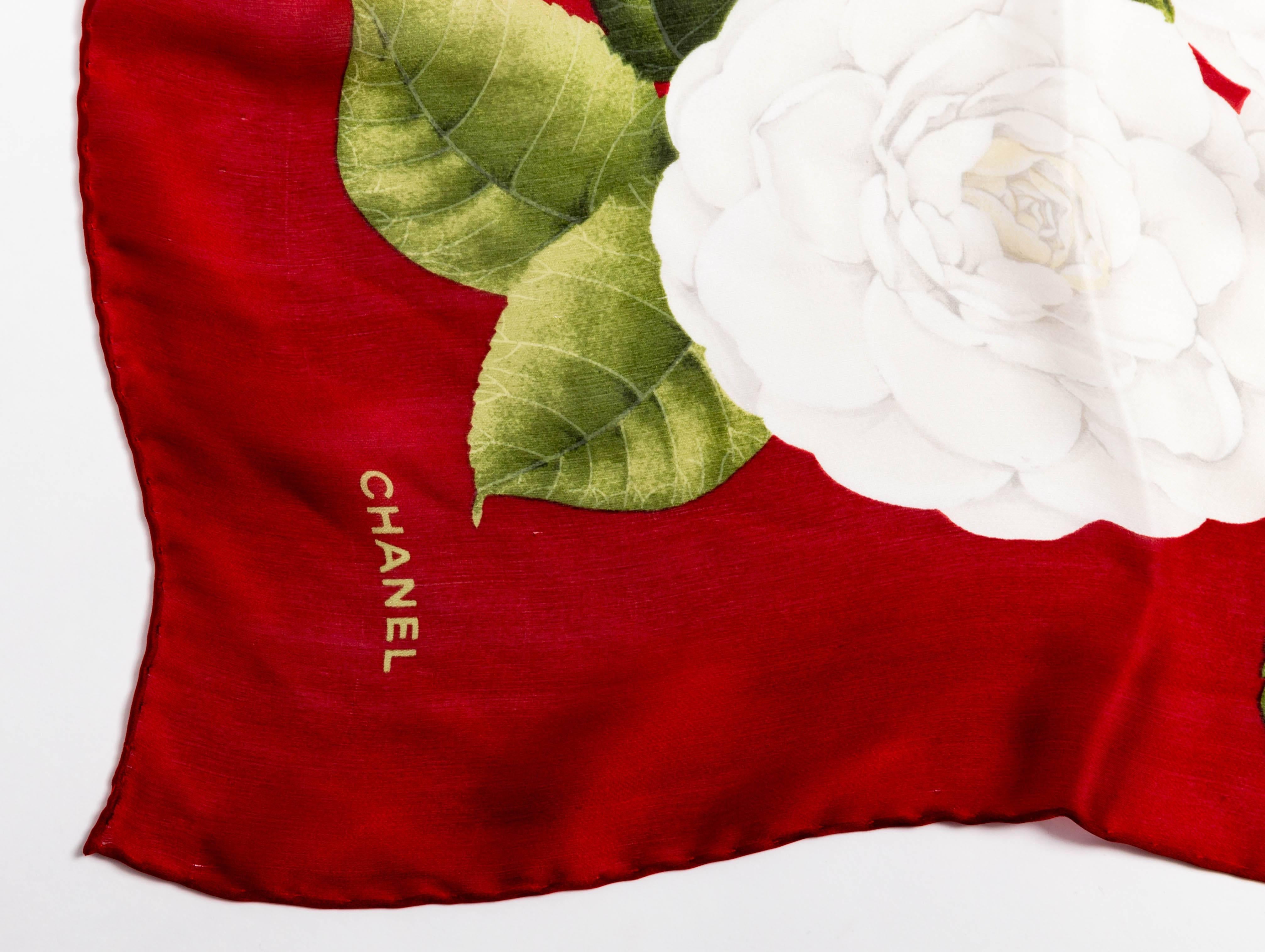 Very pretty Chanel silk scarf with white camellia flowers on a red background. Green leaves accent the beautiful camellias. 