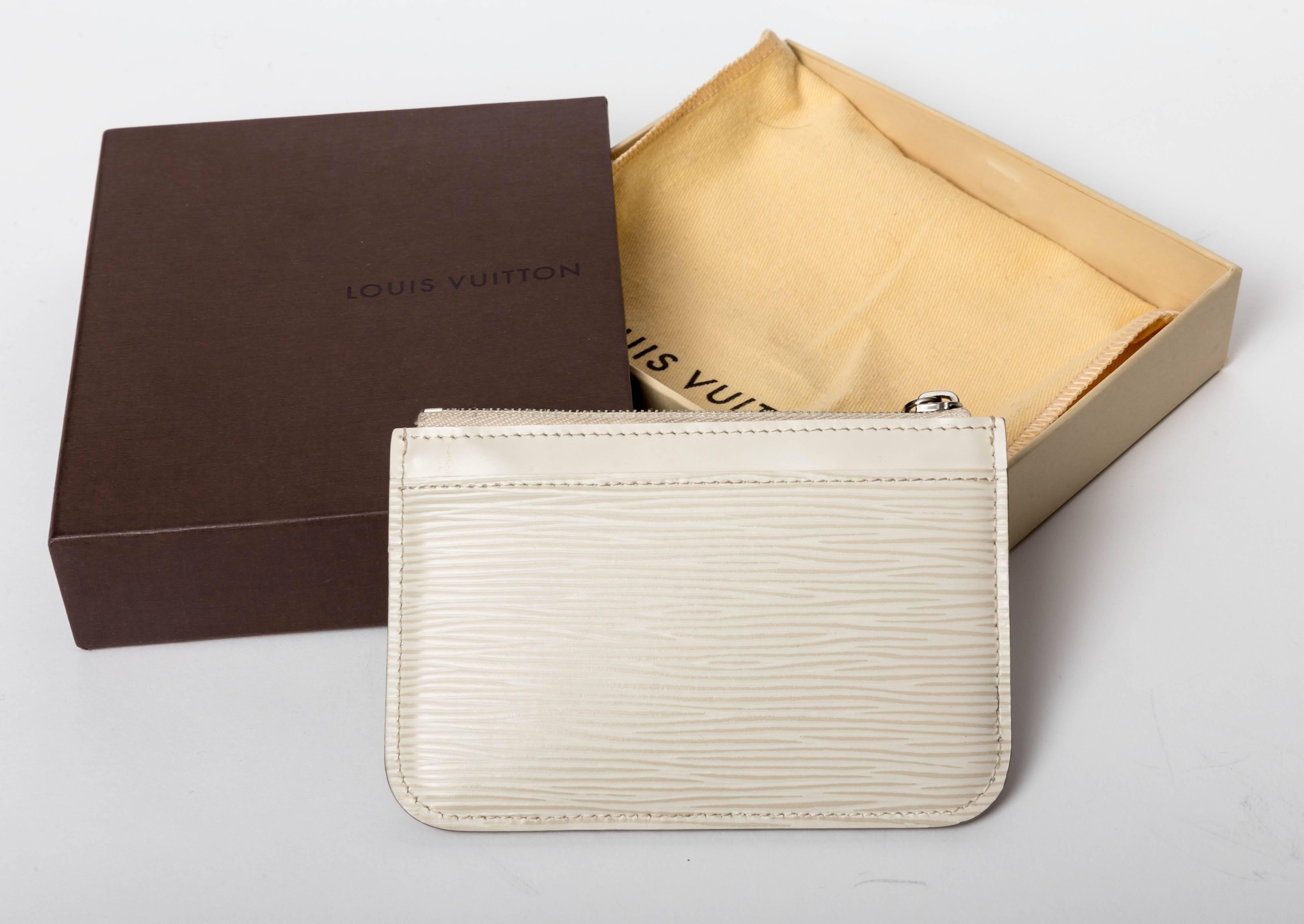 This is a new  Louis Vuitton White Epi Key Pouch. The Louis Vuitton box is included. Crafted of Louis Vuitton's signature textured epi leather, this pouch features silver hardware. The top unzips to a leather interior. This piece is both practical