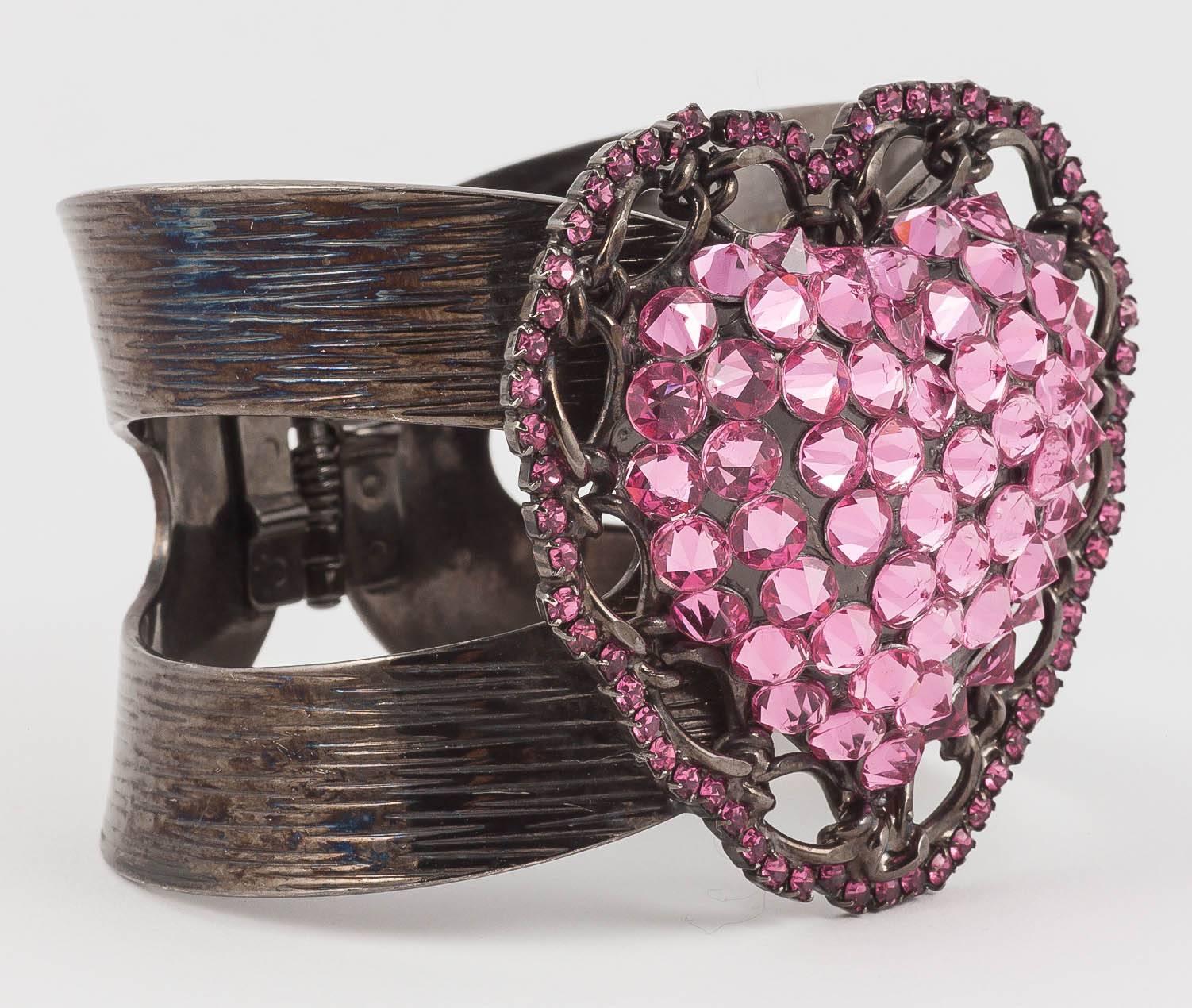 Well no one will miss you in this epic cuff! The jointed cuff is wrought in a very dark pewter colour which offsets the huge bright pink rhinestones perfectly making it look tough not just sweet. 
Lawrence Vrba designed fantastic Astec influence