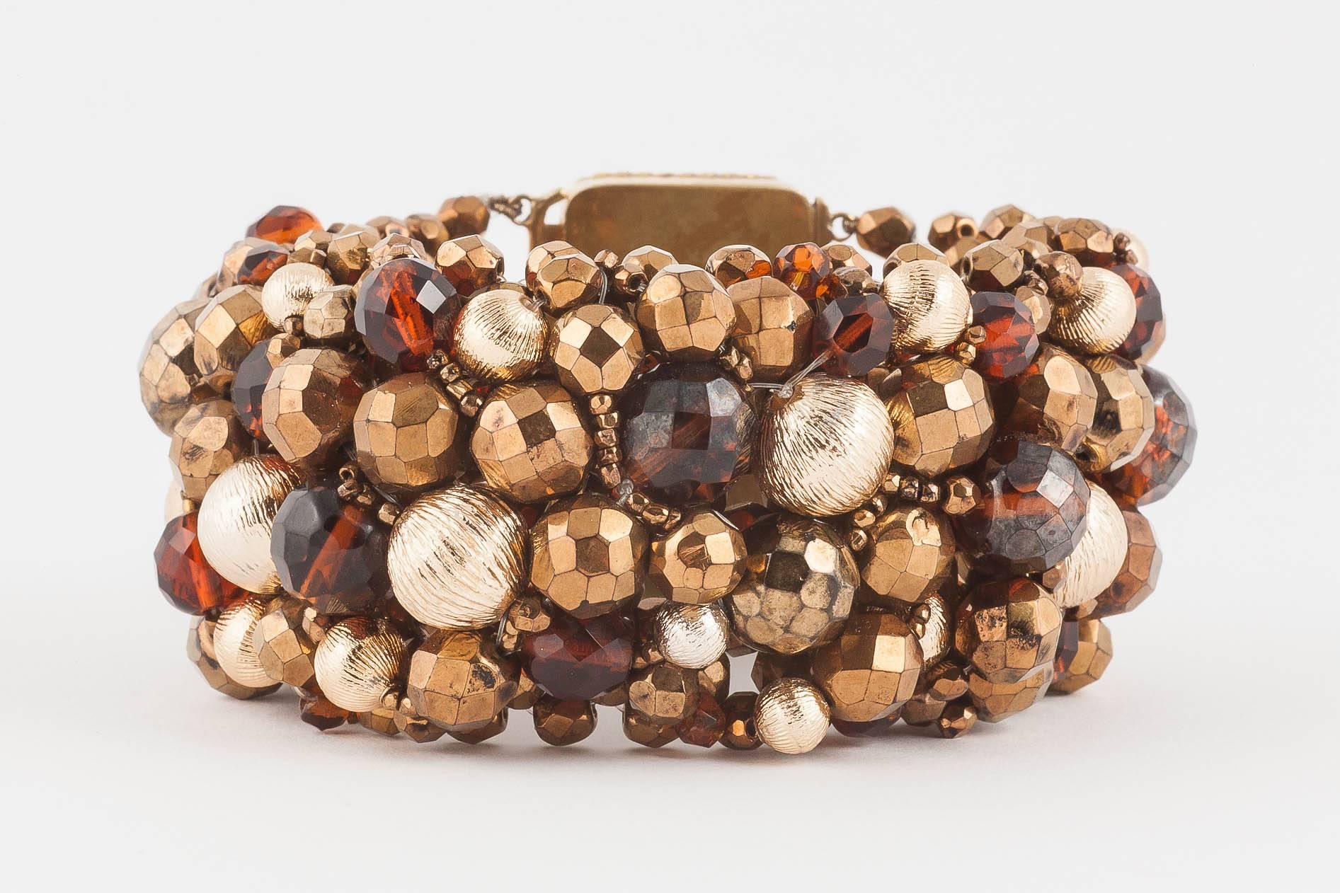 A dynamic and strong Coppola e Toppo beaded bracelet from 1964, in bronzes, browns and golds, a rich mix of Bohemian half-crystal beads and brushed gilded metal ;boules' or beads,all mounted on a web of more beads, with a large beaded signature