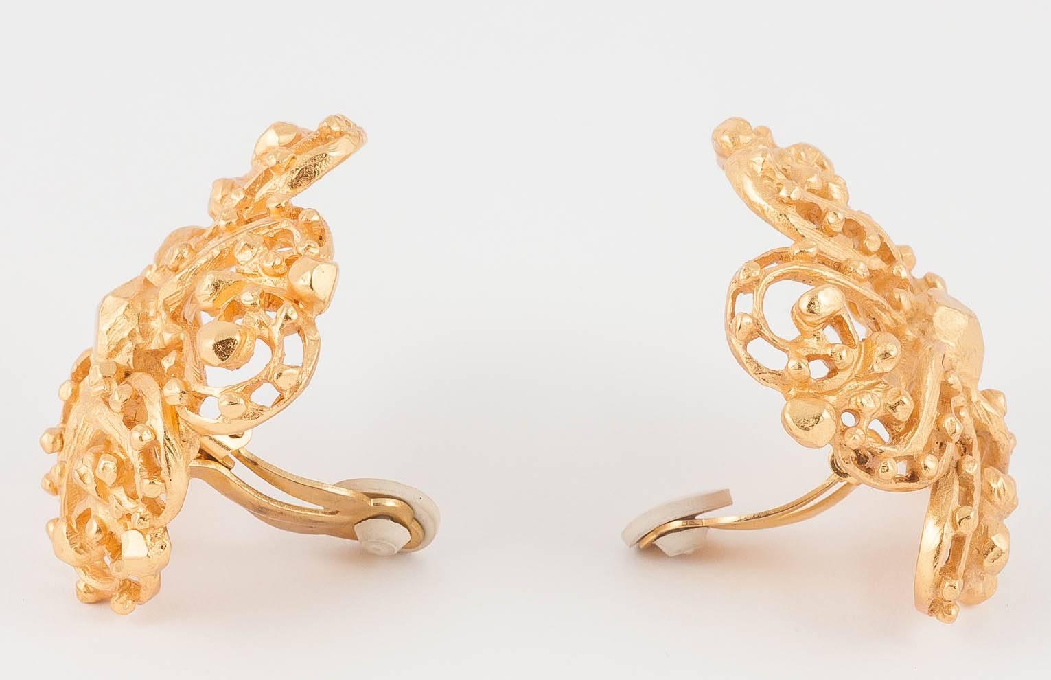 Big gilt clip on earrings were a stalwart of 1980s style and this slightly abstract style pair are classics of the genre. Slightly domed and made in an openwork form, they are lighter than they look, which adds to the comfort factor. 
It looks like