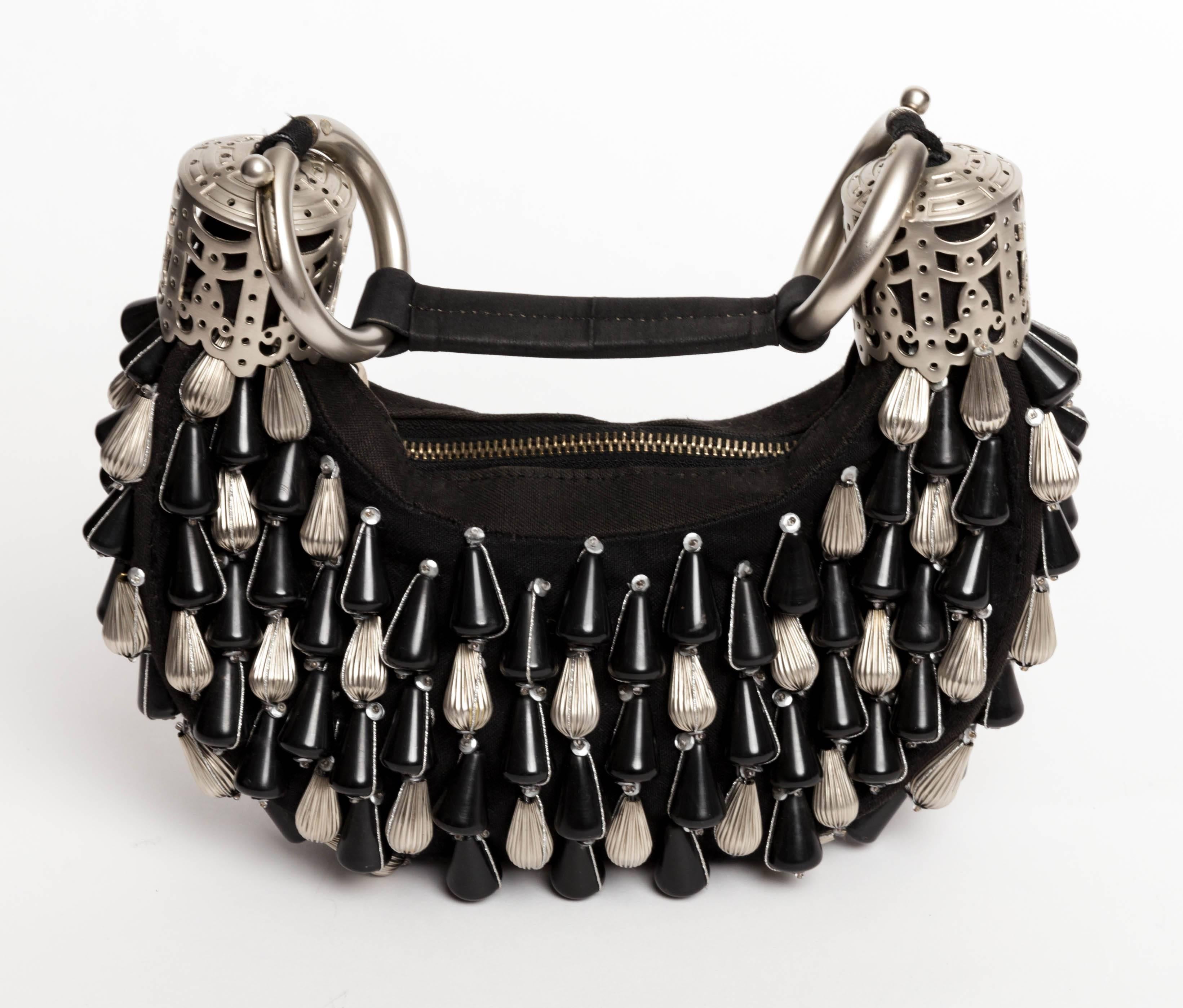 Exquis sac à bracelet Chloe conçu par Stella McCartney pendant son mandat chez Chloe.
Sac à poignée en toile noire Chloé Beaded Bracelet avec accessoires en ton argenté, ornements en perles sur l'ensemble du sac, anses plates, poche intérieure à