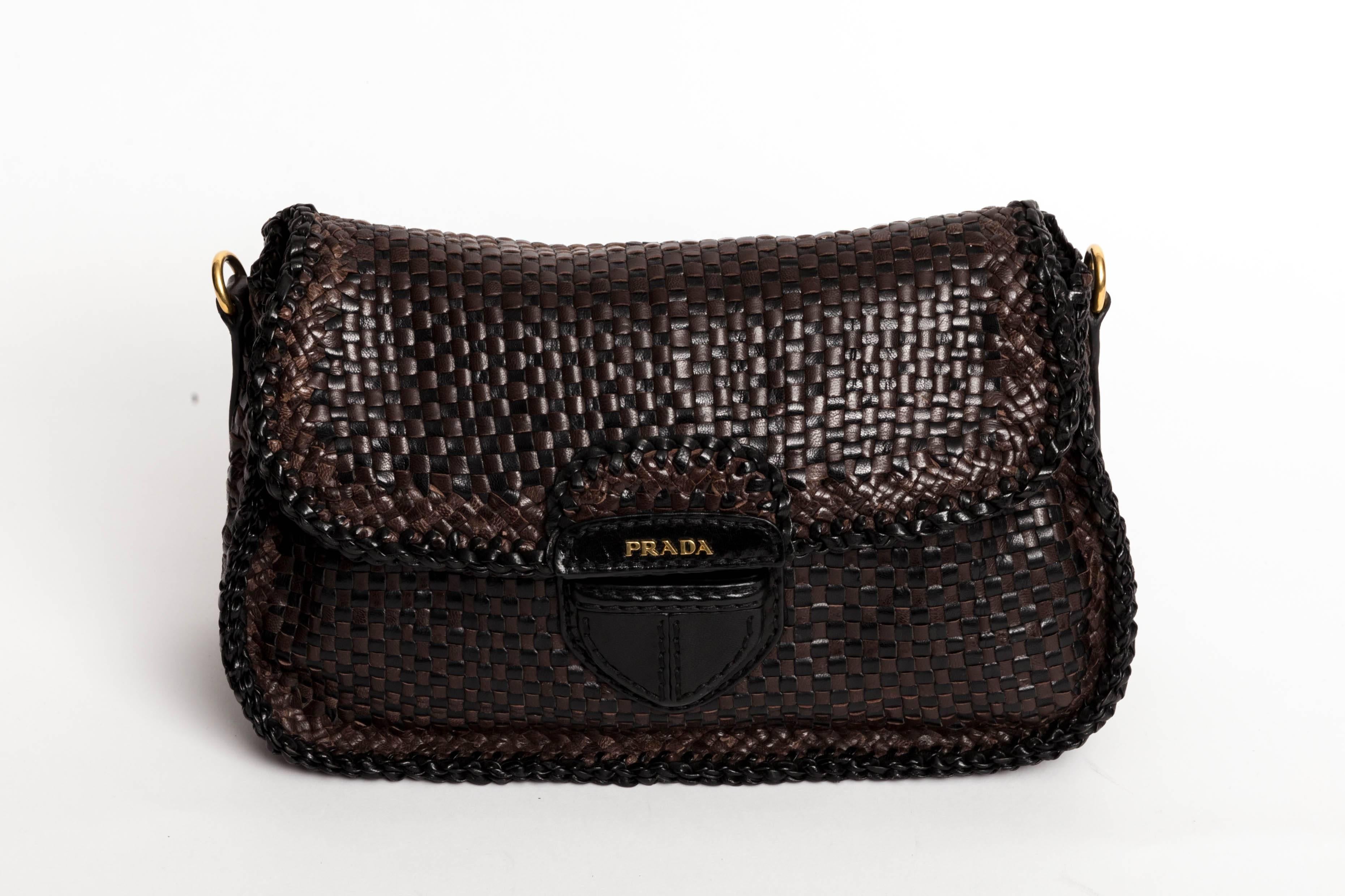 Incredibly chic Prada Limited Edition Madras Woven Leather Shoulder Bag with Detachable Shoulder Strap and Gold Hardware. This black and brown woven leather bag is in excellent condition. It can be worn cross body but also carried as a clutch. One