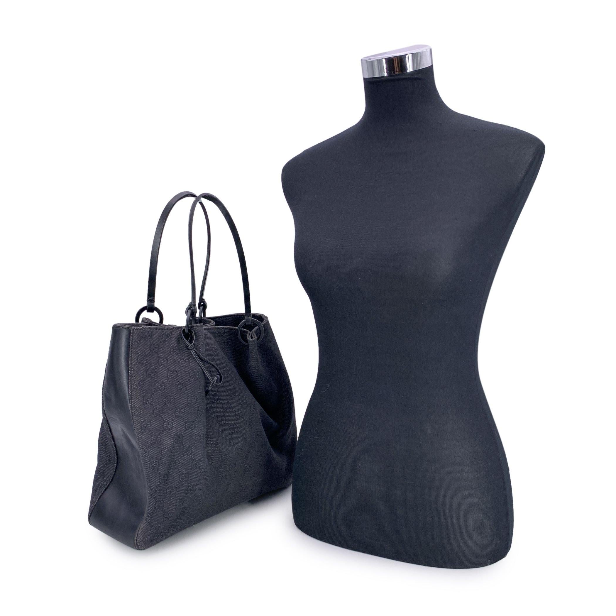 Una rara scoperta per gli amanti del denim e per i collezionisti di vintage, questa tote in tela denim nera di Gucci unisce l'utilità a uno stile innegabile. La sua silhouette strutturata ma slanciata è realizzata in ricca tela nera GG monogram, con