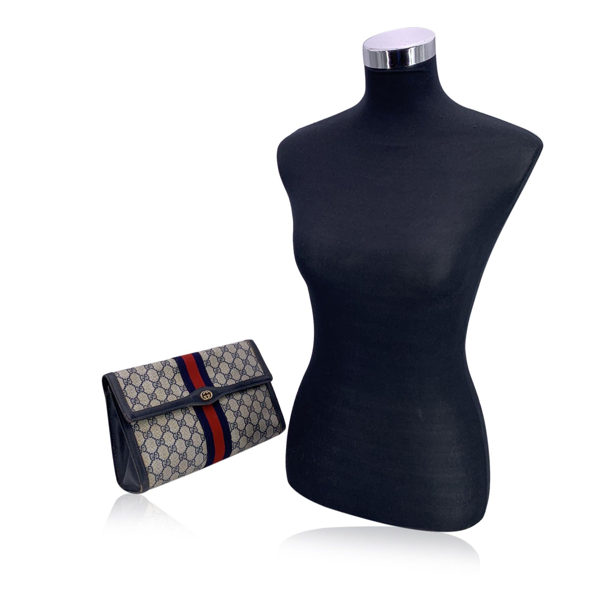 Véritable classique de l'âge d'or de Gucci, cette trousse à cosmétiques vintage à rabat de Gucci est à la fois fonctionnelle et emblématique. Confectionné en toile monogramme bleu signature et garni de cuir véritable bleu riche, il respire