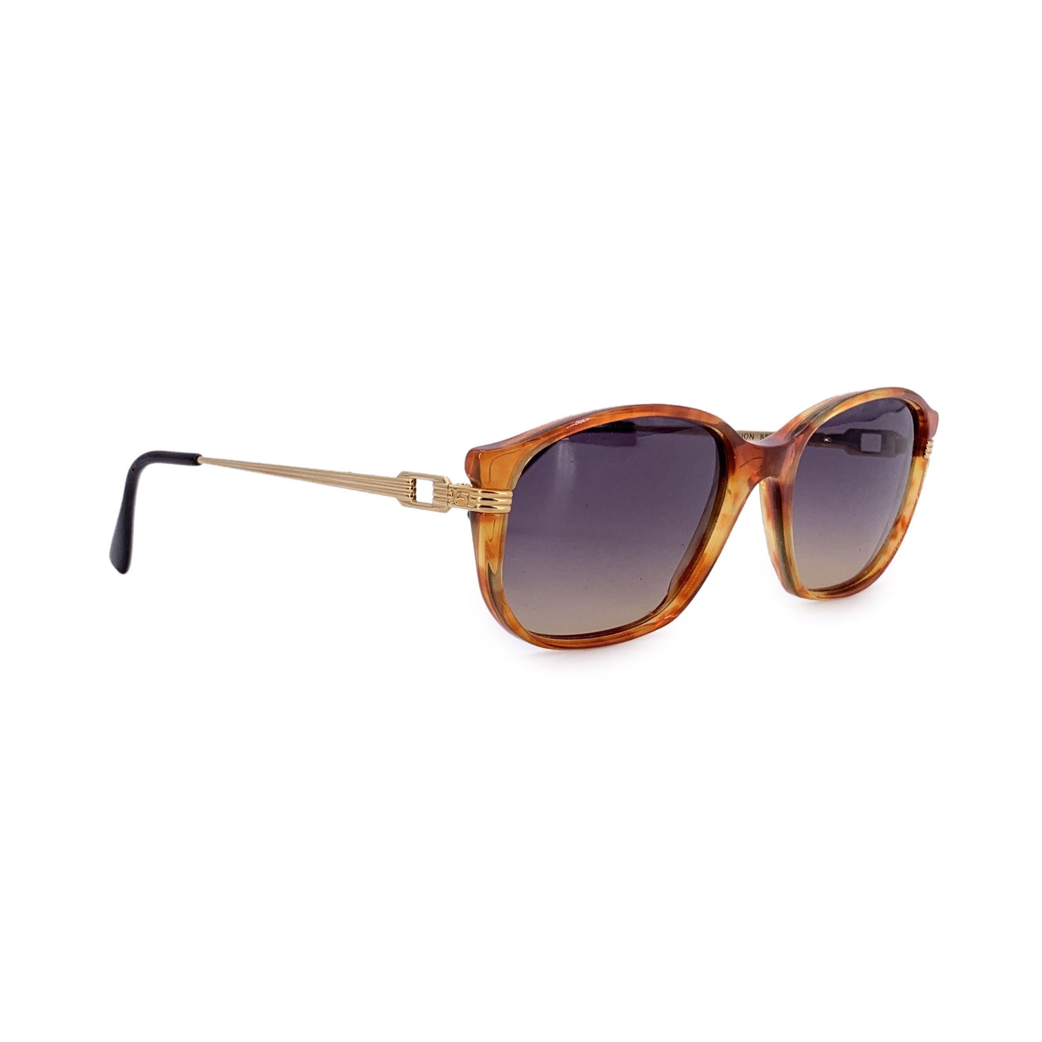 Adéntrate en la sofisticación atemporal con estas gafas de sol vintage Yves Saint Laurent, modelo TITHON. Fabricadas en Francia, estas gafas encarnan la elegancia tranquila y el espíritu audaz de la alta costura de los 90. La montura rectangular de