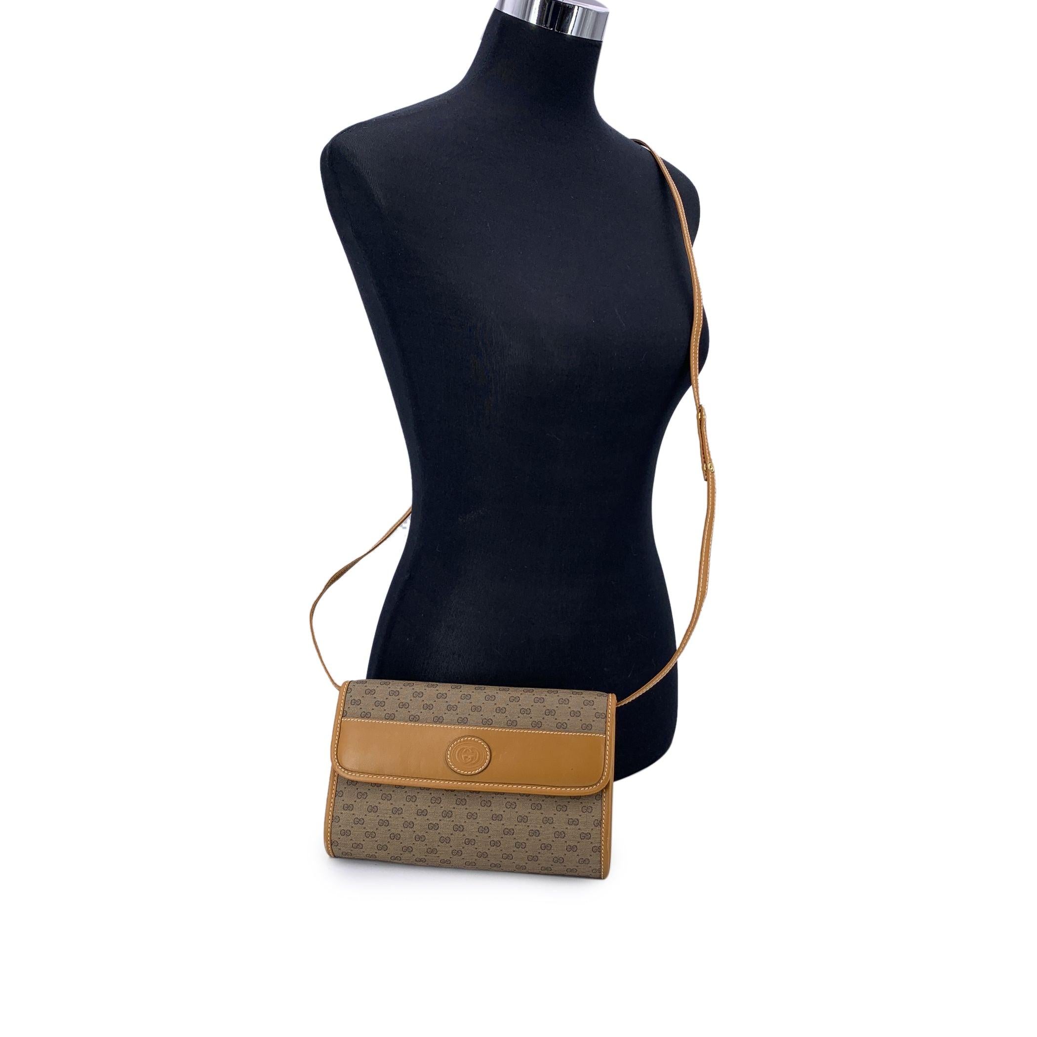 Diese schicke und kompakte Vintage-Crossbody-Tasche von Gucci ist aus dem für die Marke charakteristischen beigen Monogram-Canvas gefertigt und für ein zeitloses Finish mit Glattleder verziert. Die Vorderklappe ist mit einem Magnetknopfverschluss