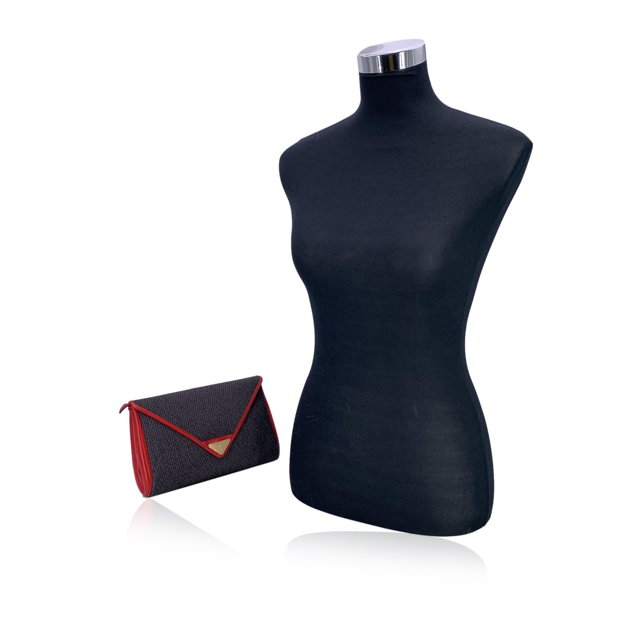 Diese schicke und zeitlose Vintage-Clutch von Yves Saint Laurent ist ein raffiniertes Statement für unaufdringlichen Luxus. Sie ist aus grauem strukturiertem Vinyl-Canvas mit auffälligen roten Lederbesätzen gefertigt und schafft mühelos den Spagat
