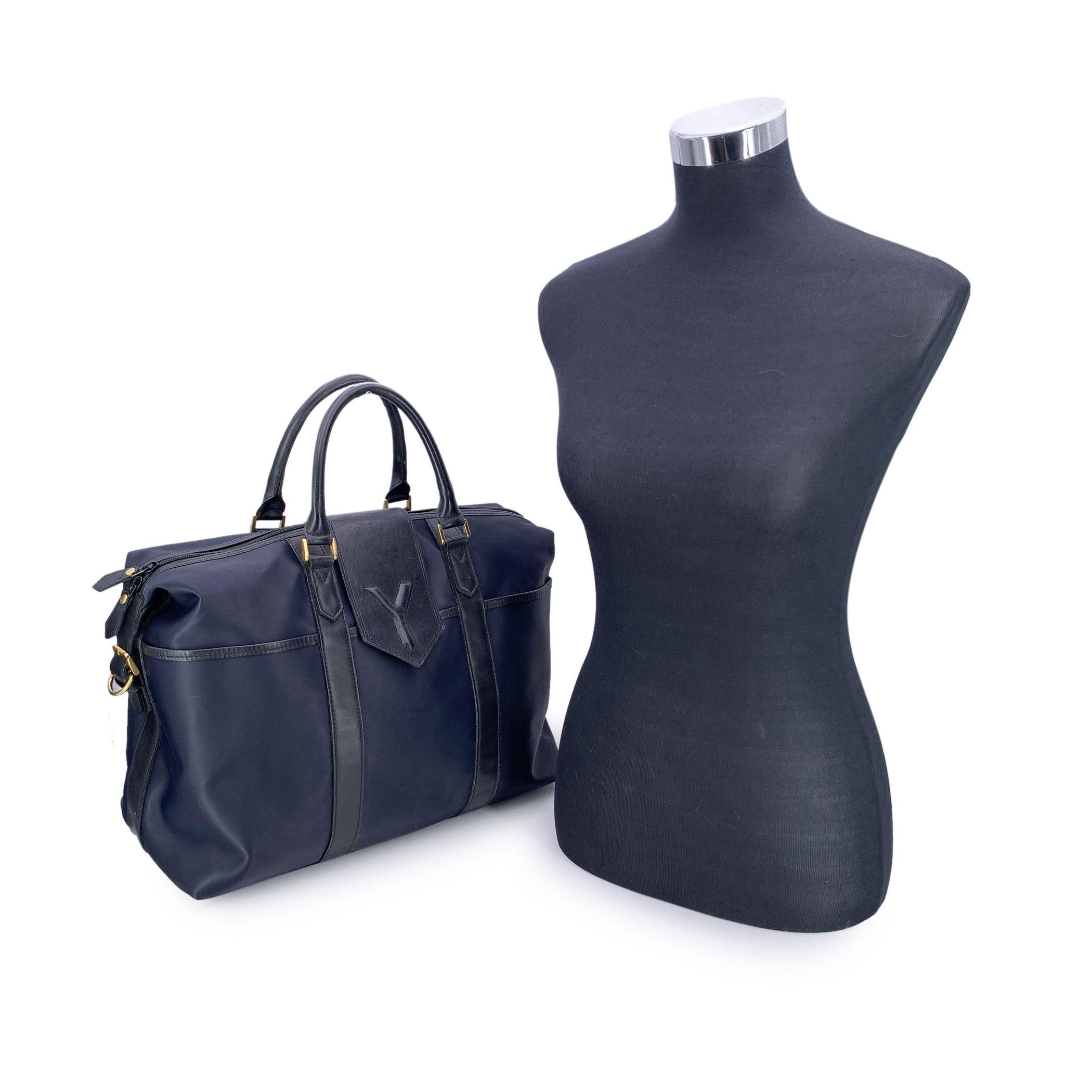Diese schöne Reisetasche von Yves Saint Laurent ist eine perfekte Mischung aus Stil und Funktion. Sie ist aus strapazierfähigem marineblauem Nylon gefertigt und mit eleganten schwarzen Lederbesätzen versehen. Der Reißverschluss an der Oberseite wird