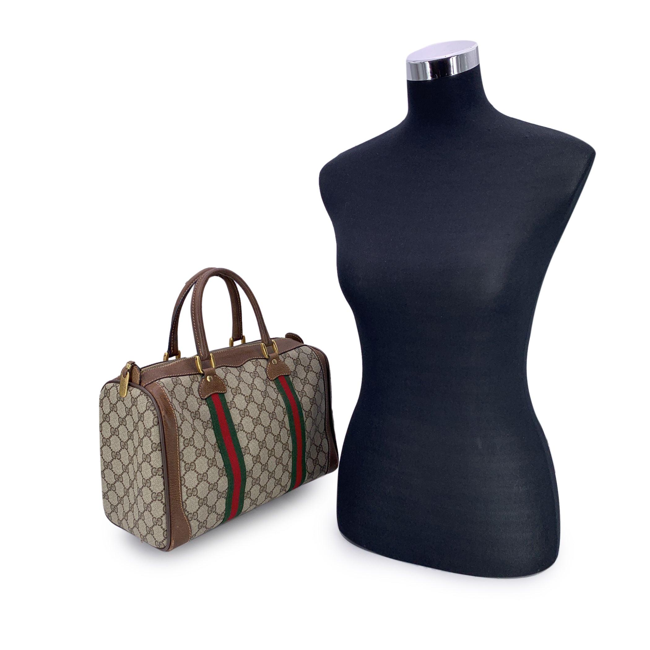 Ein wahres Schmuckstück für Vintage-Liebhaber - diese Gucci Vintage Monogram Web Duffle Boston Bag ist ein zeitloses Stück, das die Essenz des klassischen Gucci-Stils einfängt. Die Tasche aus beigem GG Canvas mit braunem Lederbesatz und robusten