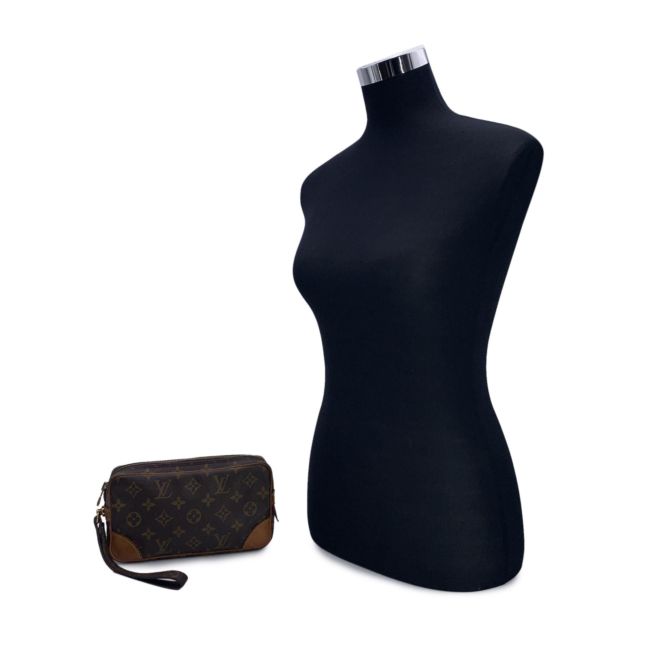 LOUIS VUITTON Monogram Canvas Marly Dragonne PM Pochette Handgelenkstasche. Brauner Canvas mit Monogrammen. Beschläge aus Messing. Vachetta-Lederbesatz in Tan. Braunes Lederfutter. Reißverschluss an der Oberseite. LOUIS VUITTON Malletier