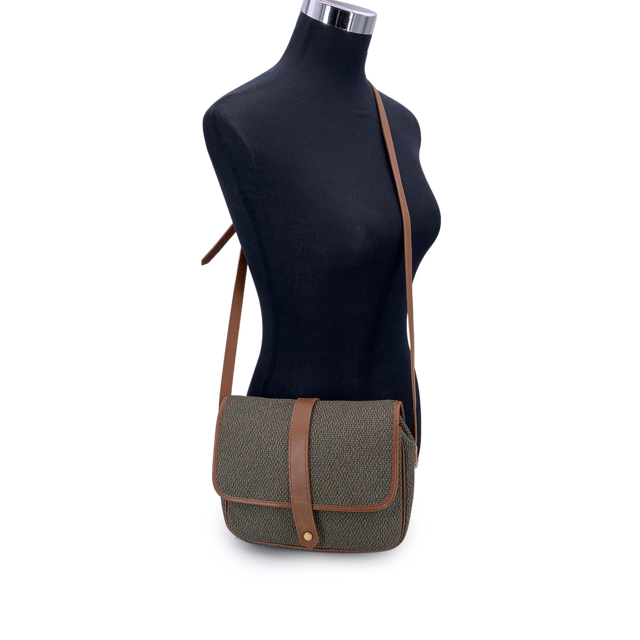 Robusta e allo stesso tempo raffinata, questa borsa crossbody vintage di Yves Saint Laurent è utile senza sforzo e con un tocco di stile parigino. Realizzata in tela strutturata verde militare con finiture in pelle marrone chiaro, unisce la