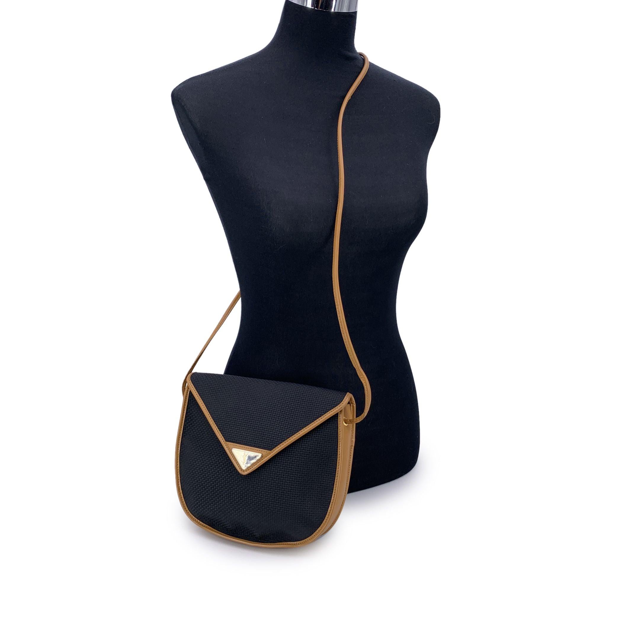 Classique et discret, ce sac à bandoulière vintage en toile texturée noire Yves Saint Laurent est une pièce raffinée du passé historique de la marque. Le corps en toile durable est encadré d'une garniture en cuir véritable, alliant la fonctionnalité