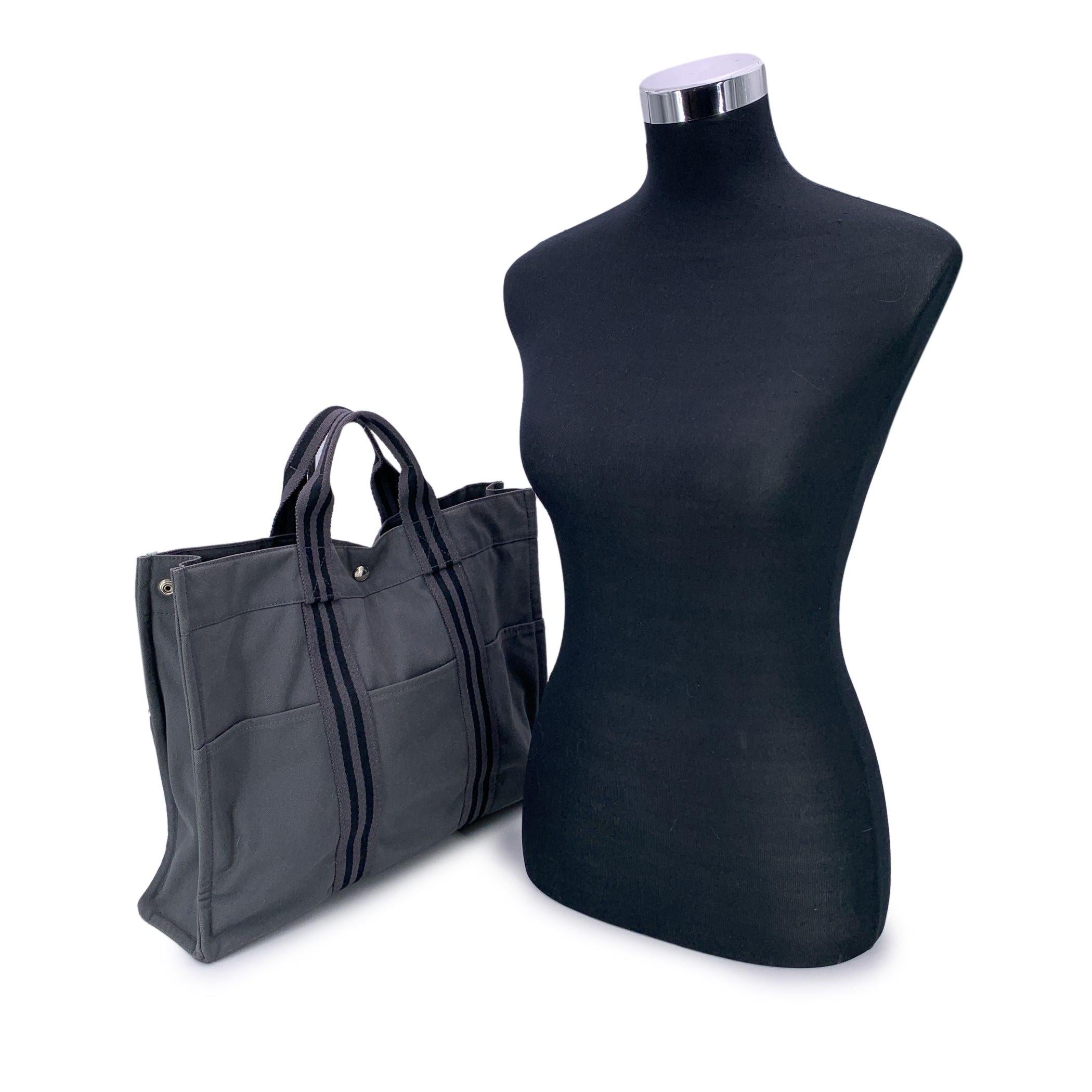 Véritable icône de l'utilité sans effort, le fourre-tout MM d'Hermès est un classique du design français understated.design. Fabriquée en France à partir d'une toile robuste 100 % coton, cette version présente un ton gris polyvalent accentué par des