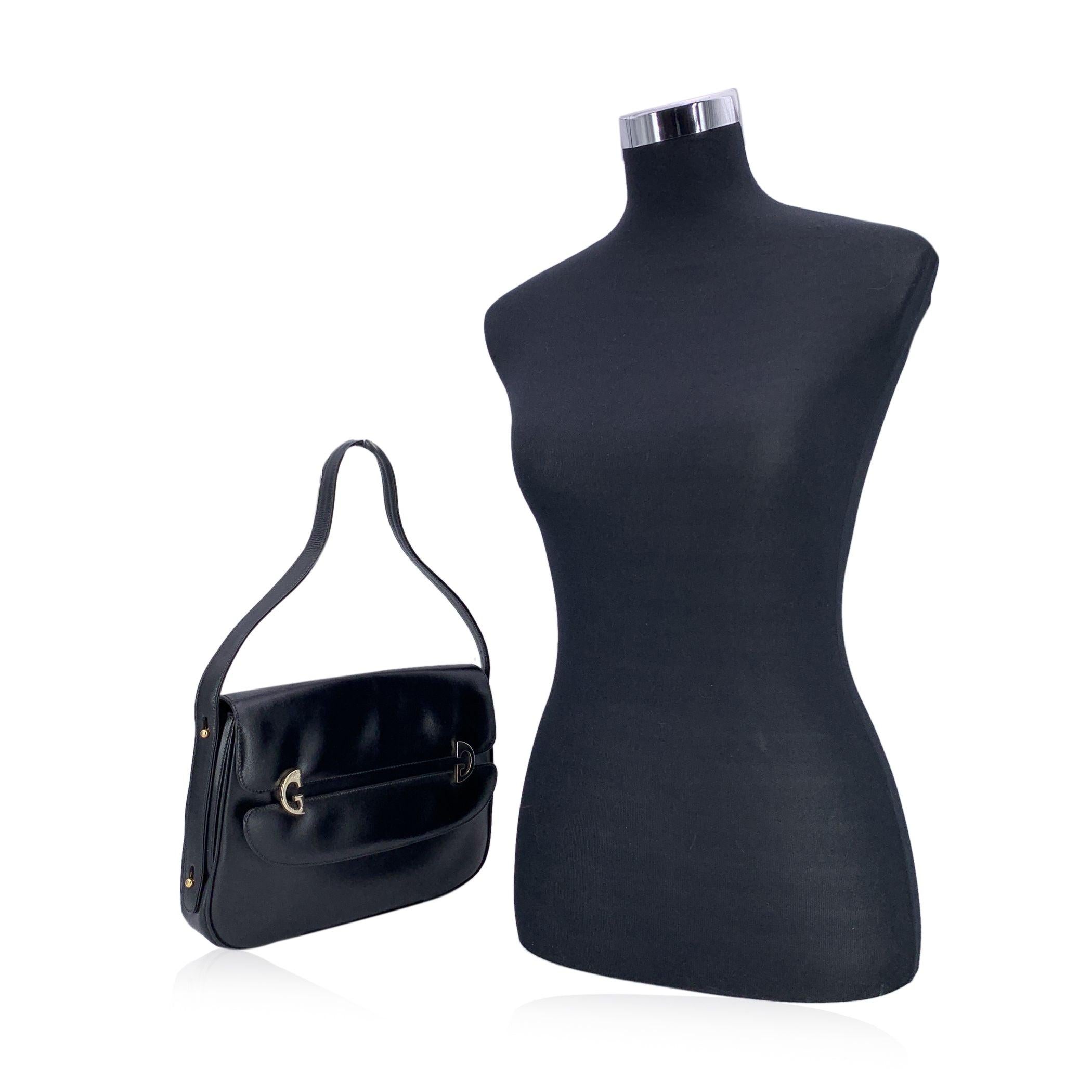Élégant et audacieux, ce sac à bandoulière vintage en cuir noir de Gucci est un exemple frappant du langage innovant de la marque en matière de design. Confectionné en cuir lisse noir, il se distingue par son rabat sculptural doté d'une découpe