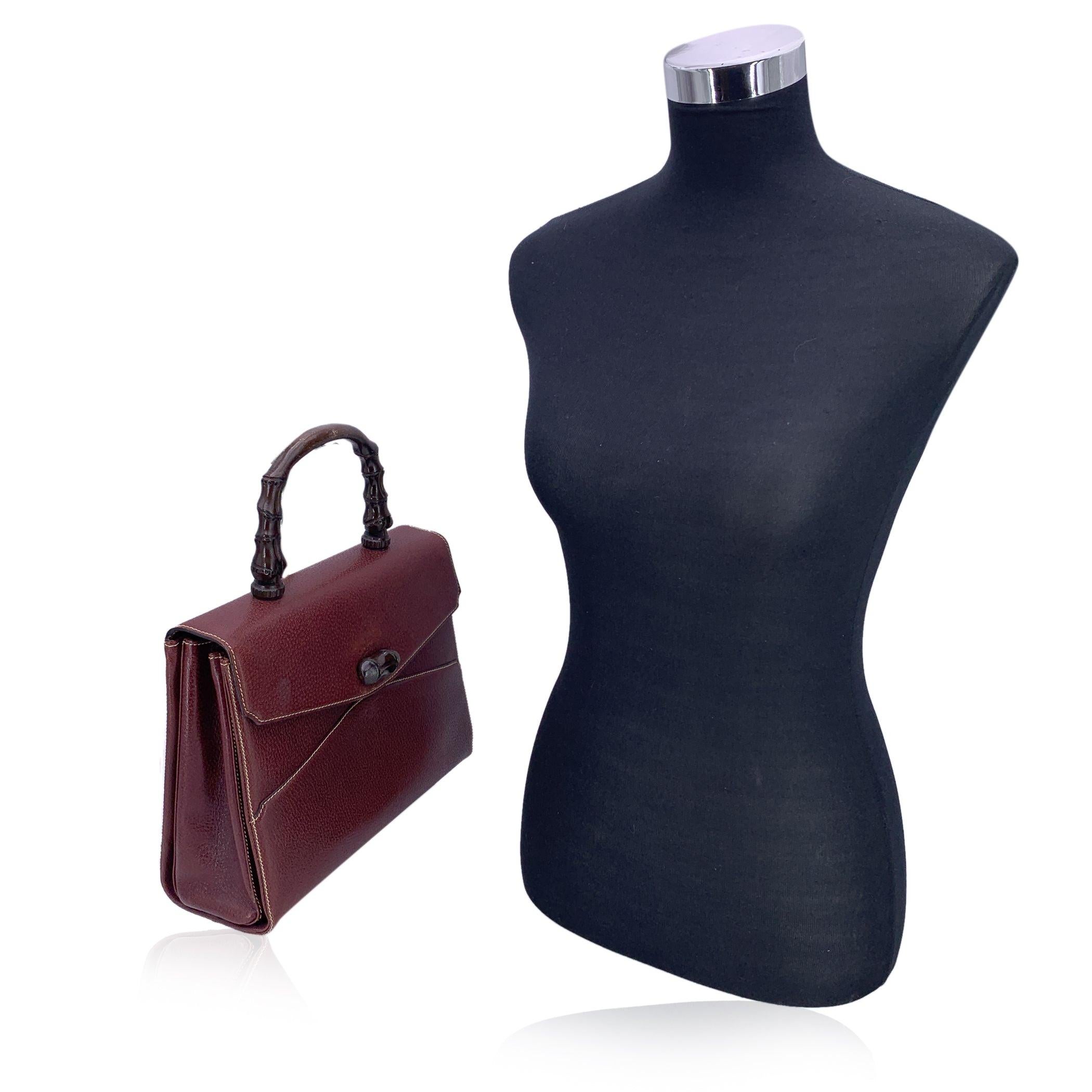 Ce sac à main Gucci en cuir brun rougeâtre (presque bordeaux foncé) est une pièce frappante de l'artisanat italien vintage. Il s'agit d'une trouvaille rare qui respire l'élégance d'antan avec une touche de charme terrien. Il se distingue par sa