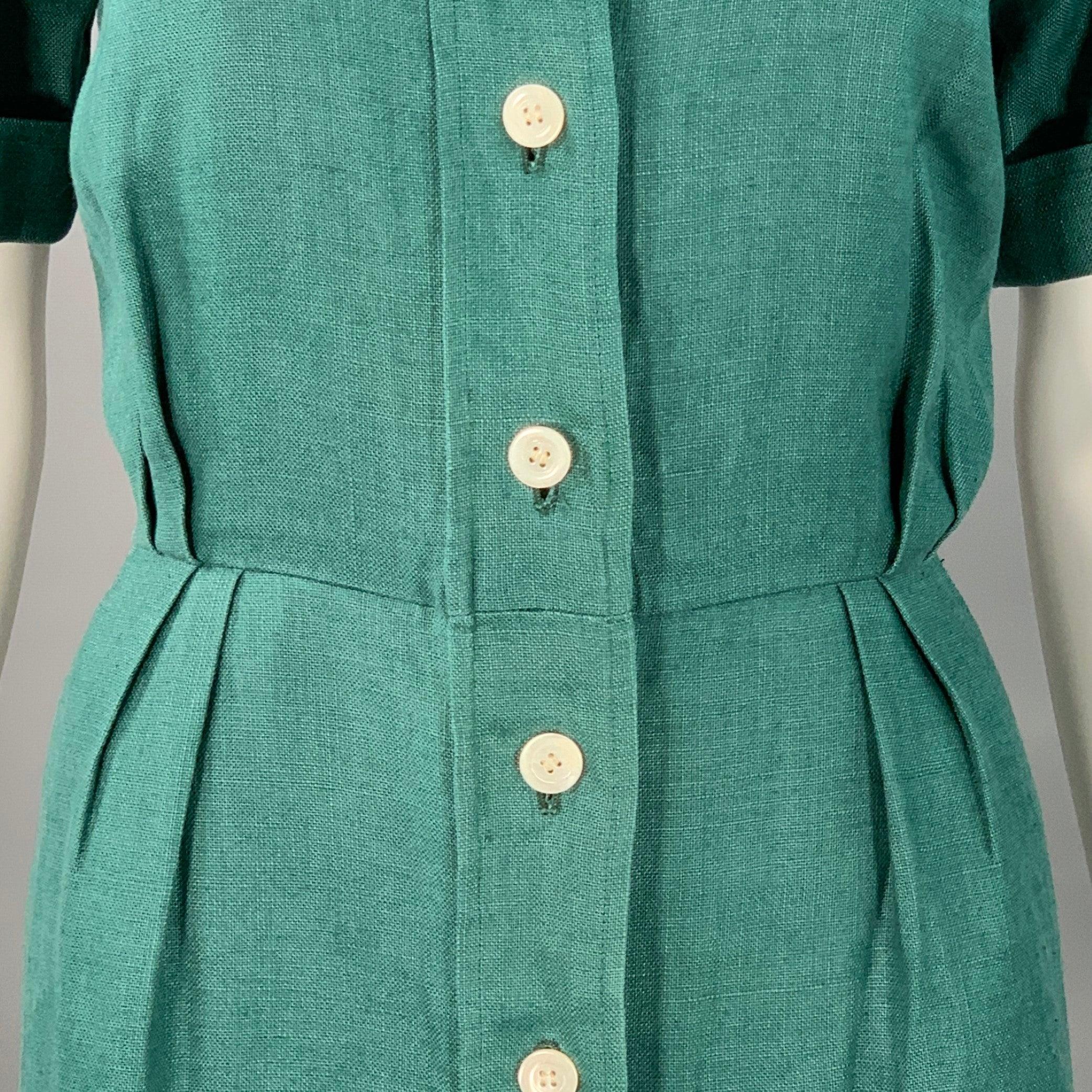 Yves Saint Laurent RIVE Gauche, abito camicia d'epoca
in tessuto di lino verde con stile plissettato, maniche corte con polsini, lunghezza midi e chiusura con bottoni. Made in France.Eccellente condizione di usato. 

Contrassegnato:   IT 42
