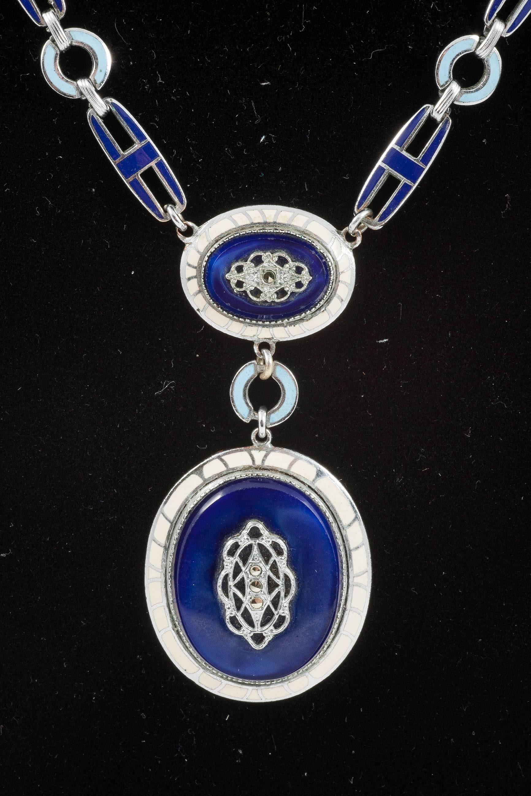 This is a really smart Deco pendant, each link is enameled in navy blue and pale blue. The double pendant is framed in a lovely cream enamel, and it has a cut steel panel attached to the glass plaques that look like Lapis Lazuli.
I think it would be