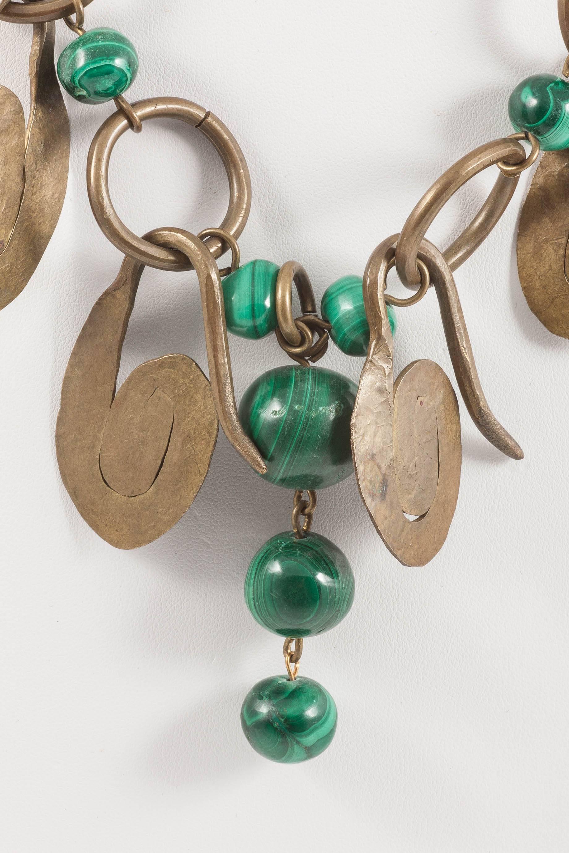 This is a fantastic artisan made necklace from the late 1950s or early 1960s. Made of brass hammered swirls and solid malachite beads of graduating size, it is a great Summer piece, with anything from khaki and white with jeans, to a full on
