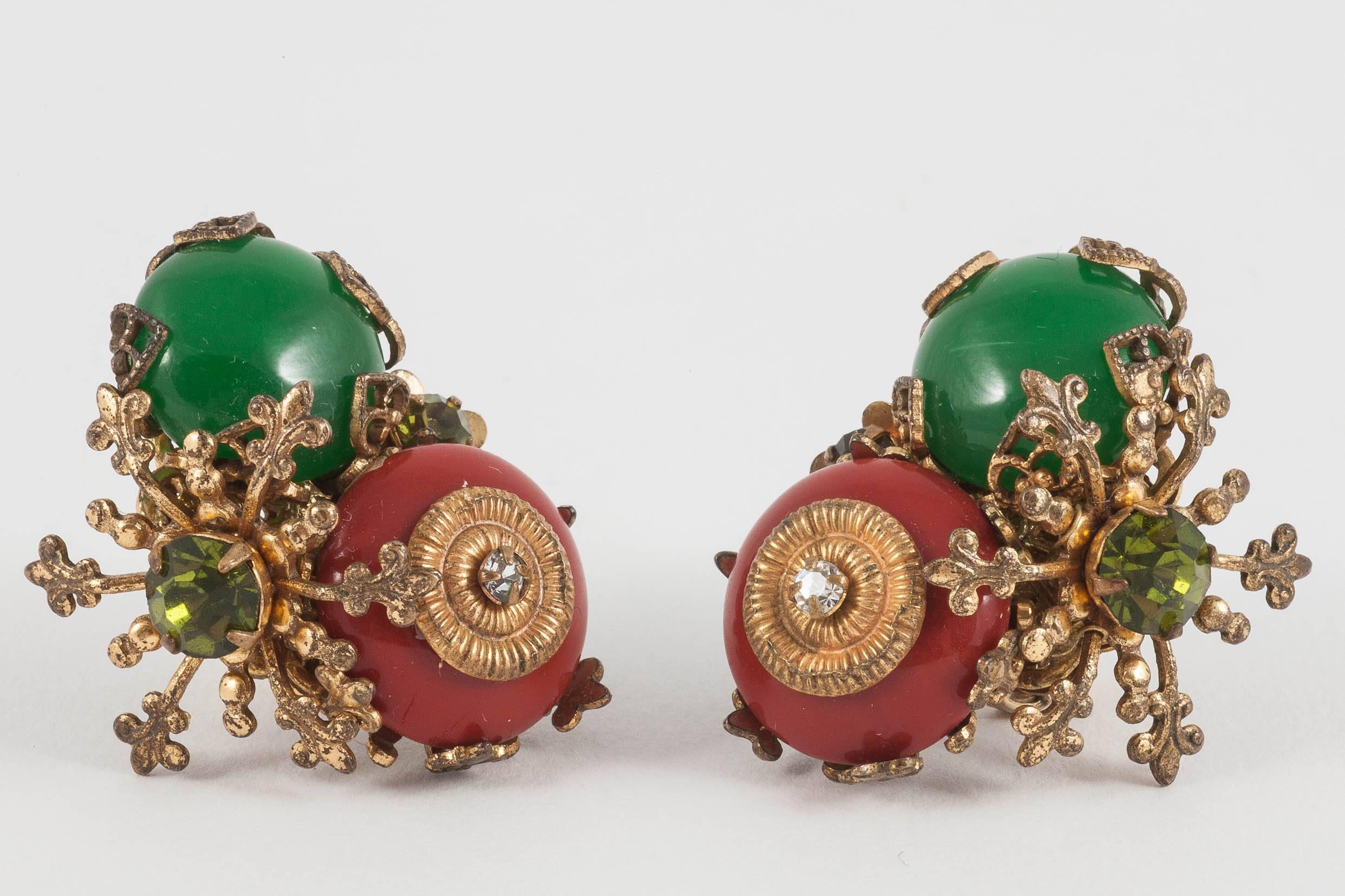 Charming opaque cornelain red and green glass earrings from Miriam Haskell in the 1950s. Designed by Frank Hess for the company, they are set in gilded metal, with filigree decoration, the two colours are high lighted with a peridot green paste -