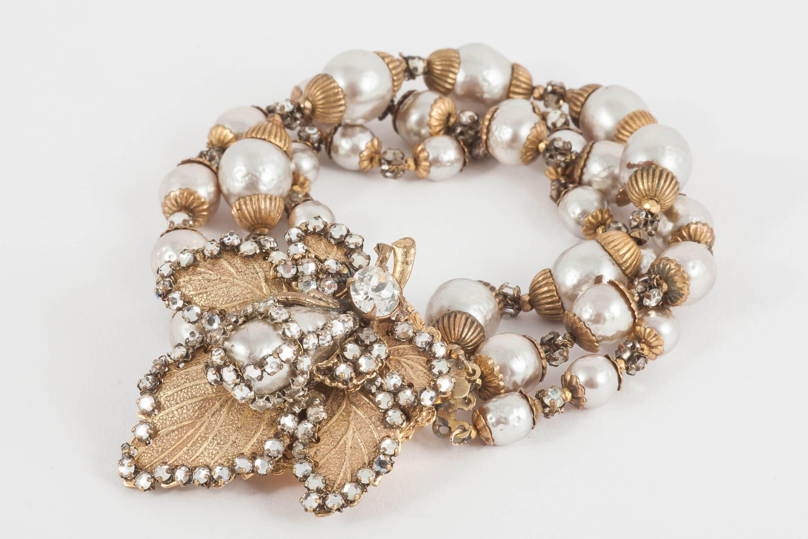 Beautifully made gilded metal, baroque pearl and hand set rose montes bracelet , with large 'leaf' matching earrings, the same motif mirrored in the clasp of the bracelet. The long baroque pearls on both the clasp and earrings are 'caged' in a