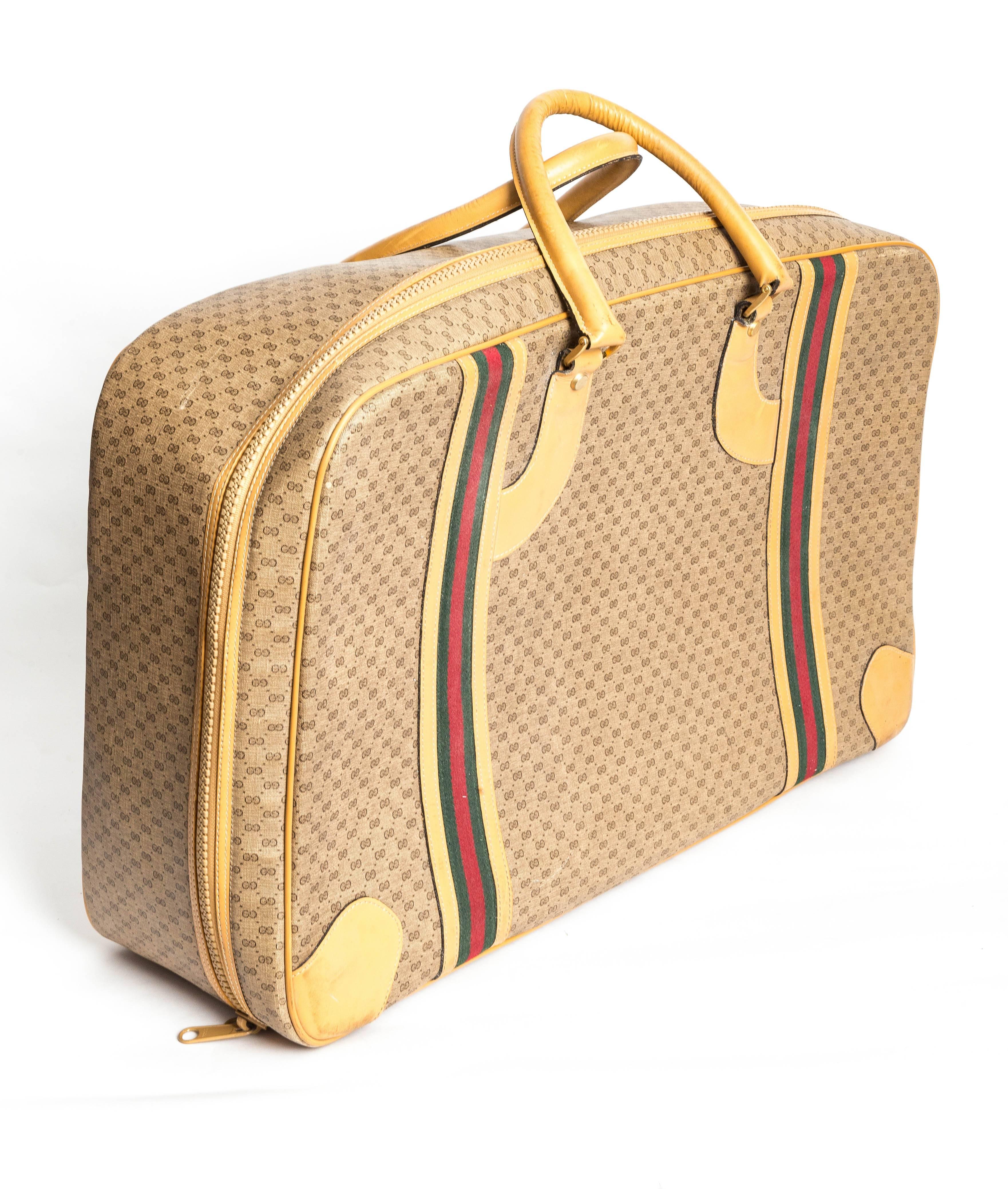 Fabulous Gucci Monogram Zip Suitcase withHeritage Stripe
Tan Logo Exterior with Tan Leather Handles 
Some Marks to Exterior and Interior
Heritage Striped Straps to Interior
25 inches wide x 15.5 inches high
