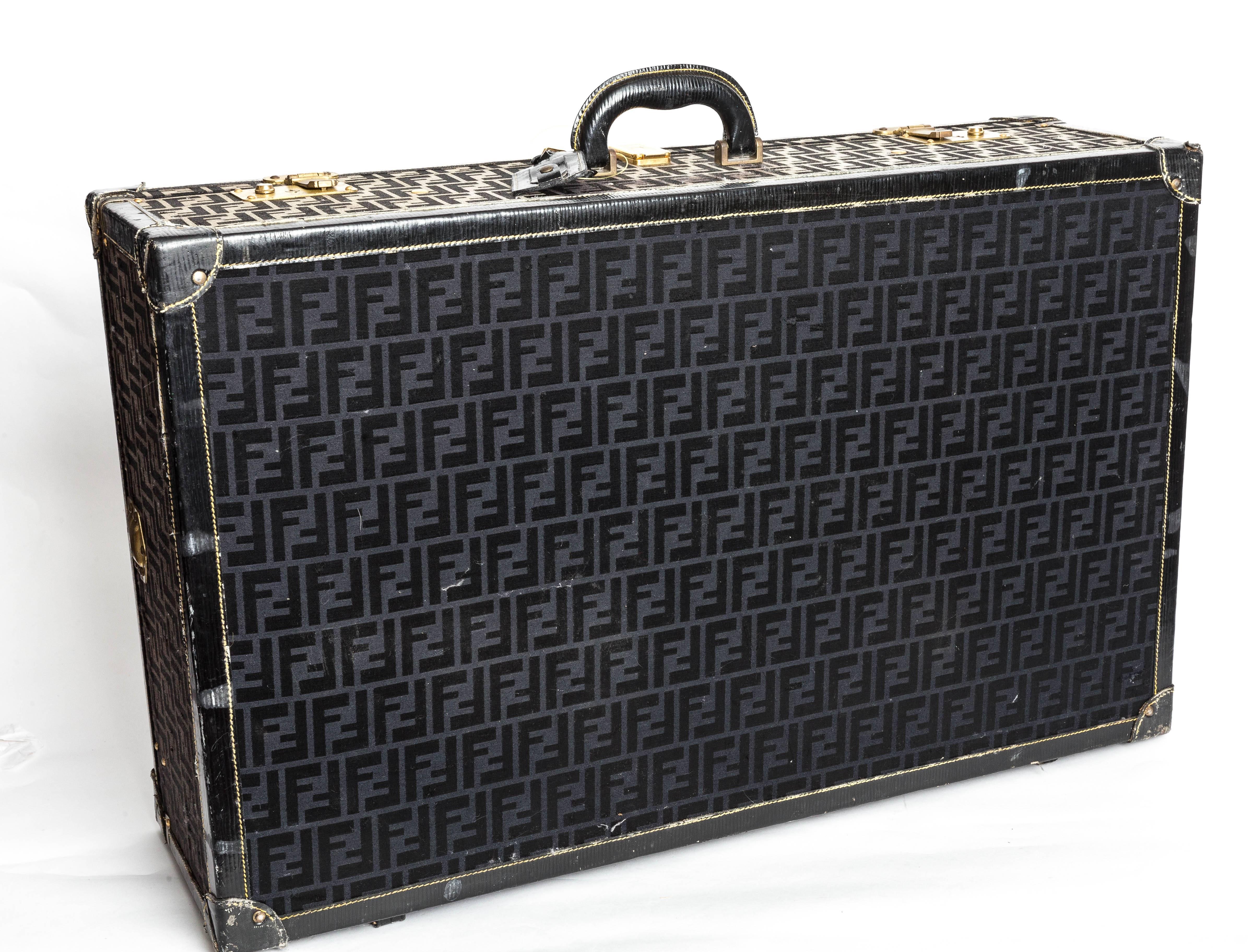 Travel in style with this sturdy travel piece from Fendi. Made in the early 1980s, this hard-sided suitcase can also be used for interior design! It features a logo-embossed interior with two leather straps for securing clothing. The exterior is