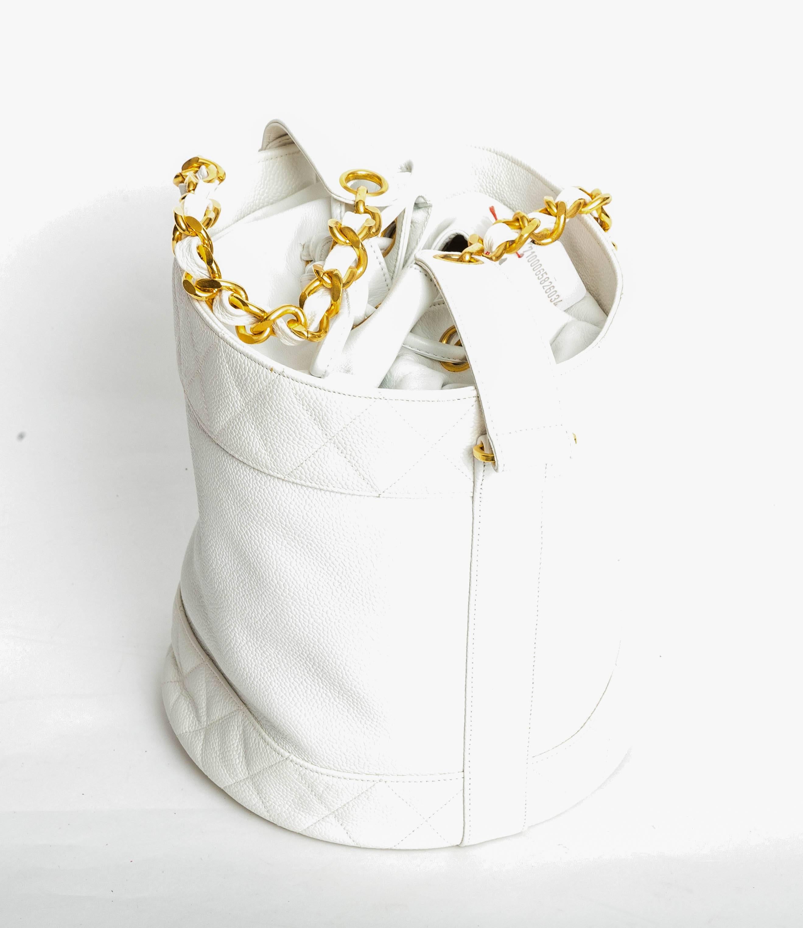 Incredibly Chic Chanel White Caviar Drawstring Bucket Bag With Gold Hardware 
Excellent Condition
Attached small pouch.
One tiny mark to interior. Exterior including bottom of bag is in excellent condition.
Hologram and authenticity card number