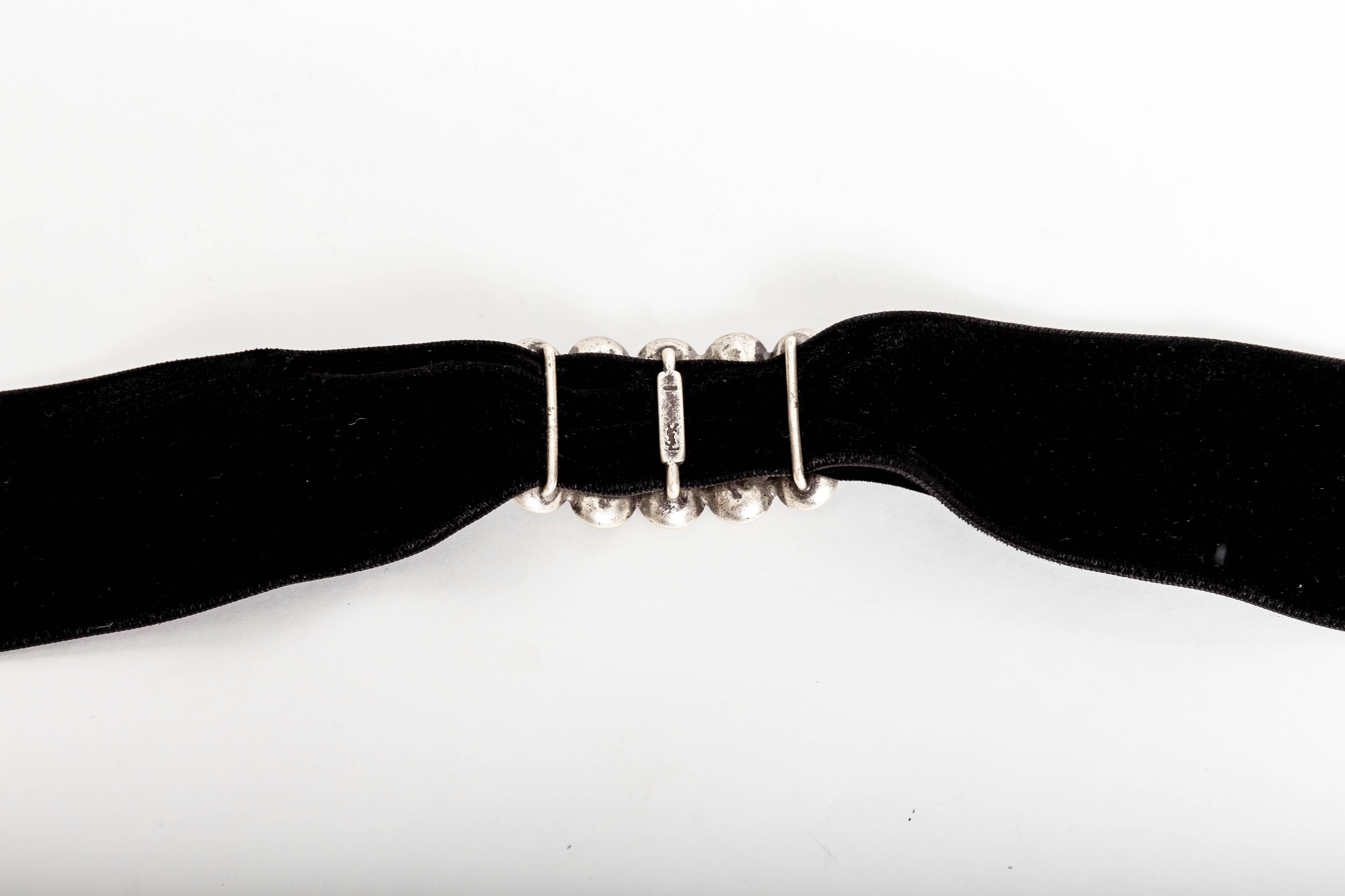 Sensational crystal YSL choker on velvet band.
May also be worn as a bracelet when wrapped several times around the wrist.
Ribbon measures 2 inches wide x 27 inches long.
Center piece contains 10 faceted crystals and measures 4 inches long x almost
