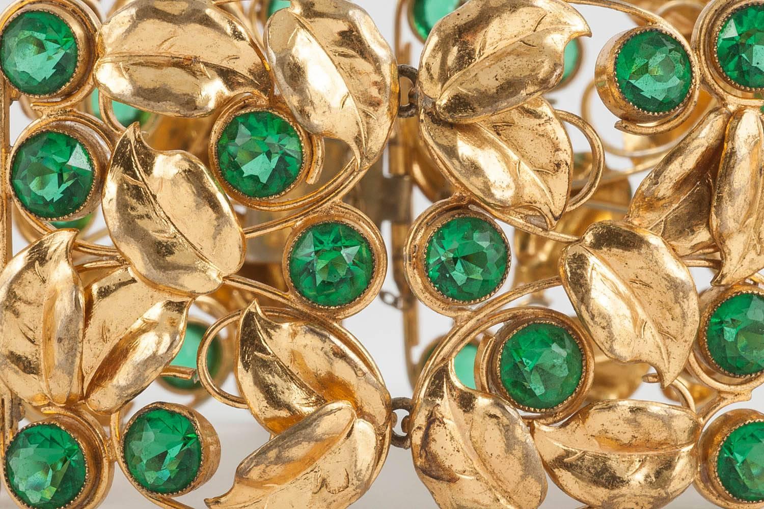 I love the bold jewellery of the 1940s. This bracelet has many of the best elements of the era. A very sculptural use of panels of leaves, with very sparkly green paste accents, makes this piece both modern and romantic.
Probably originally designed