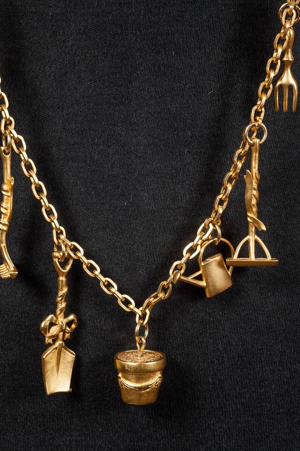 A glorious necklace, of excellent quality!
Designed by Karl Lagerfeld for his own label in the 1990s, this necklace is made with assorted 'gardening' tools and objets, cascading from a very simple classic chain,  all in a soft matt gilding. Spades,