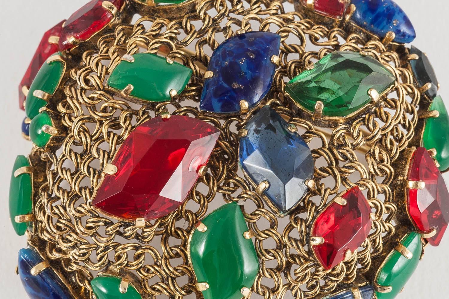 Cleverly constructed in gilded metal chain, woven in an asymmetrical 'basket' form, using unusually shaped stones of ruby, sapphire and emerald colours, some clear, others opaque.  This is a really unusual piece. One of Grosse Germany's earlier