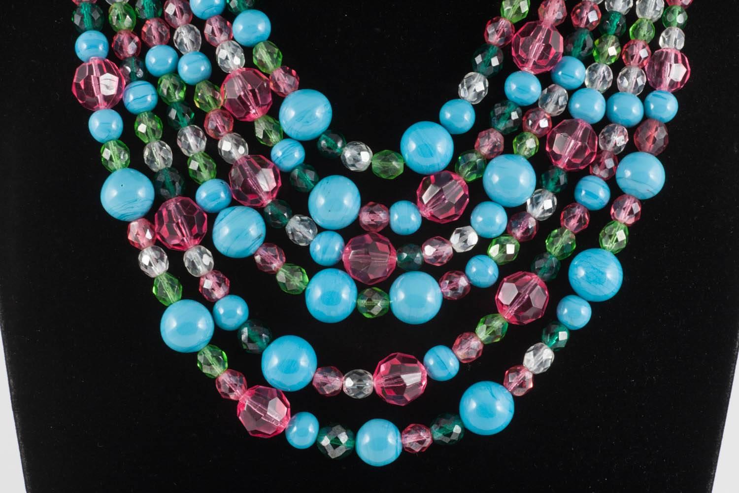Ravishing colours of turquoise, raspberry, clear and deep peridot are scattered over six graduated rows of this elegant necklace from Coppola e Toppo from the 1950s. 
Of varying cut and size, they are spread through out the necklace, in a non