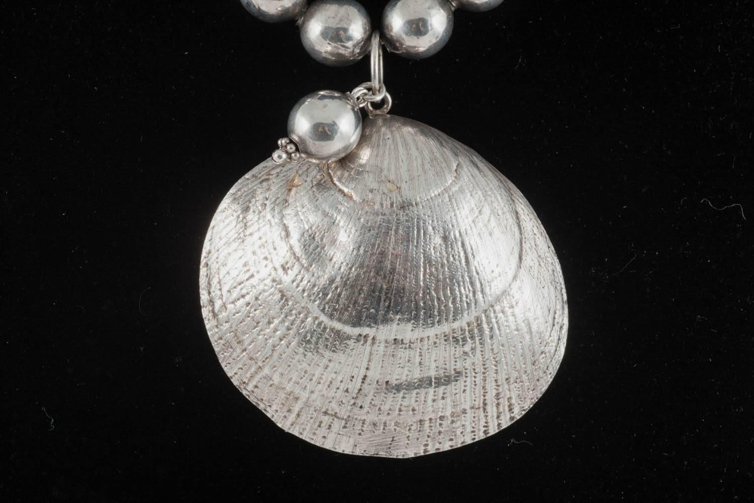 This is a bold, wearable necklace that benefits from being virtually weightless. The ball dangling at the front of the shell also sits snugly behind the pendant like a pearl nestling in its shell. Only you will know that it is there. I am not able