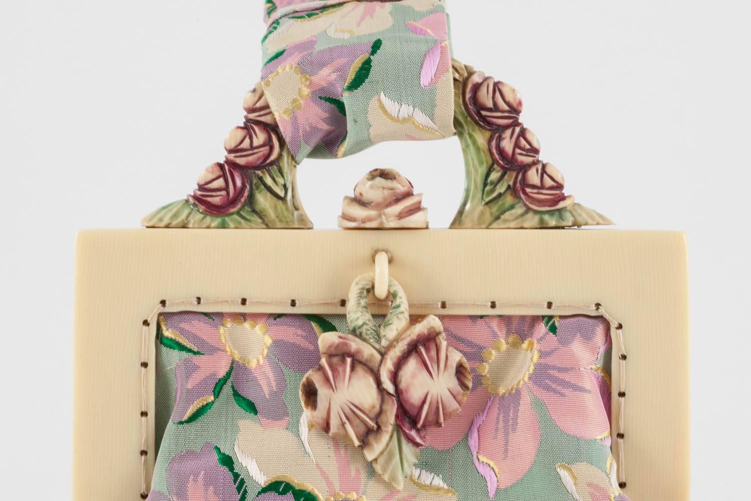 An exquisite and unique little handbag, with a carved Bakelite and hand coloured frame, in a stylised floral motif, with a beautifully coloured silk 'floral' fabric bag. Lined in chartreuse silk with a delicate silk 'floral' trim, it has a secure