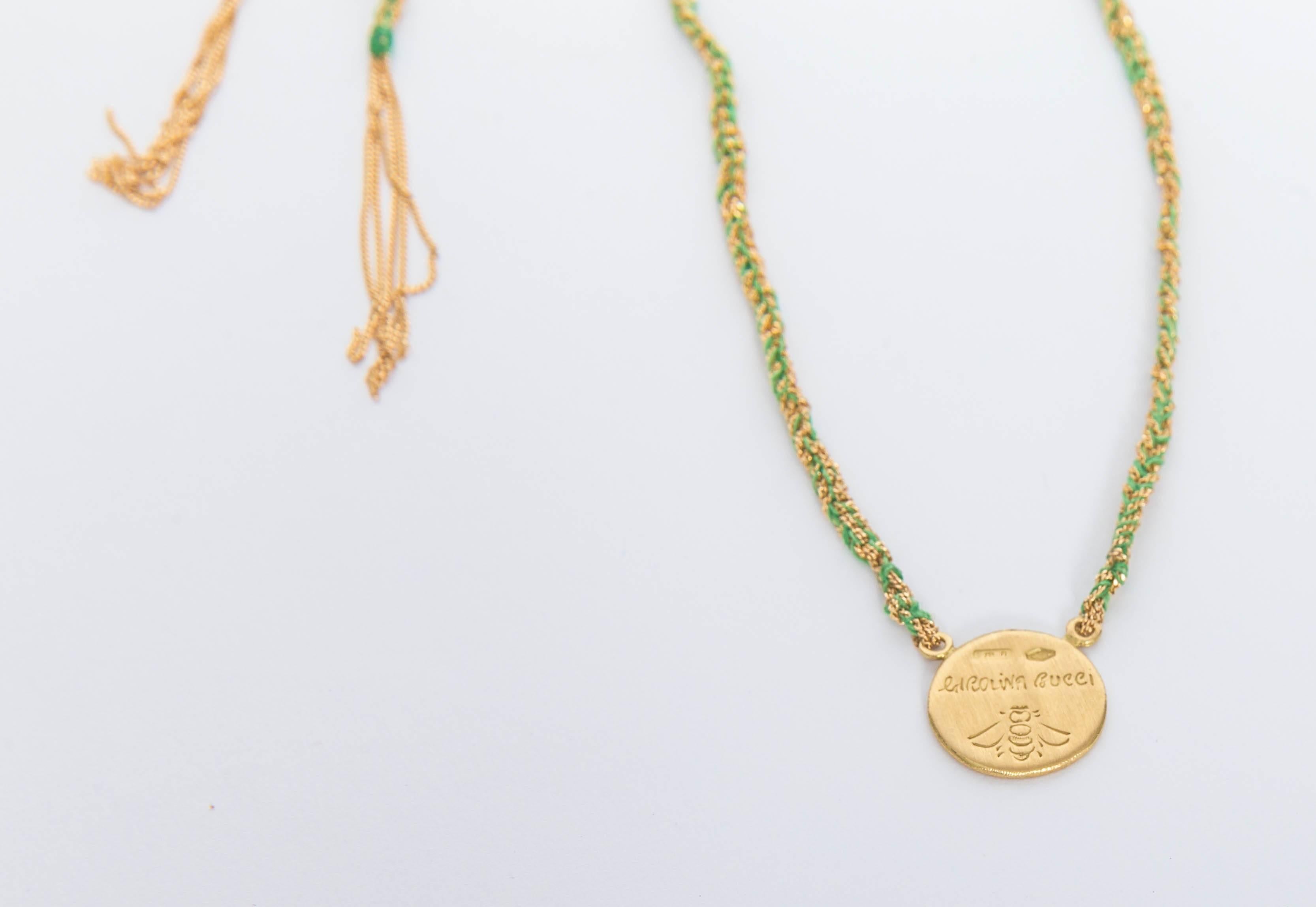 Carolina Bucci 18 kt Gold and Silk $ Money Pendant Necklace / Lariat 
This beautiful necklace features a gold disc with a dollar sign outlined in diamonds.
Stunning 18 kt Yellow Gold diamond-cut chain, hand braided with Apple Green silk ends in gold