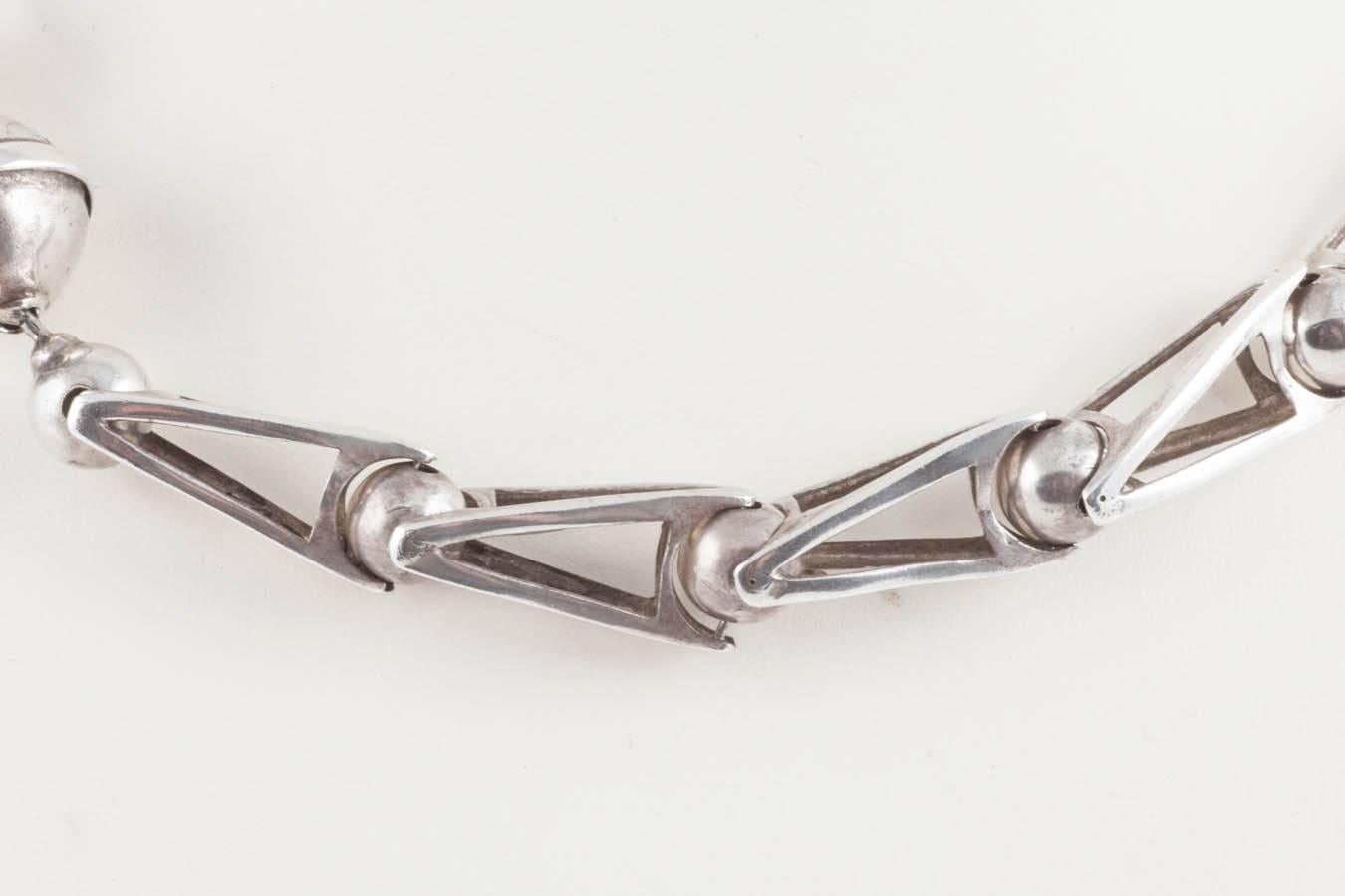 This is a beautifully made sterling silver necklace with a fantastically unusual and ingenious clasp. It is hallmarked  '925' and '92' below, with possibly 'a tree', possibly made in 1992 in Glasgow, Scotland, giving its year of manufacture as 1992.