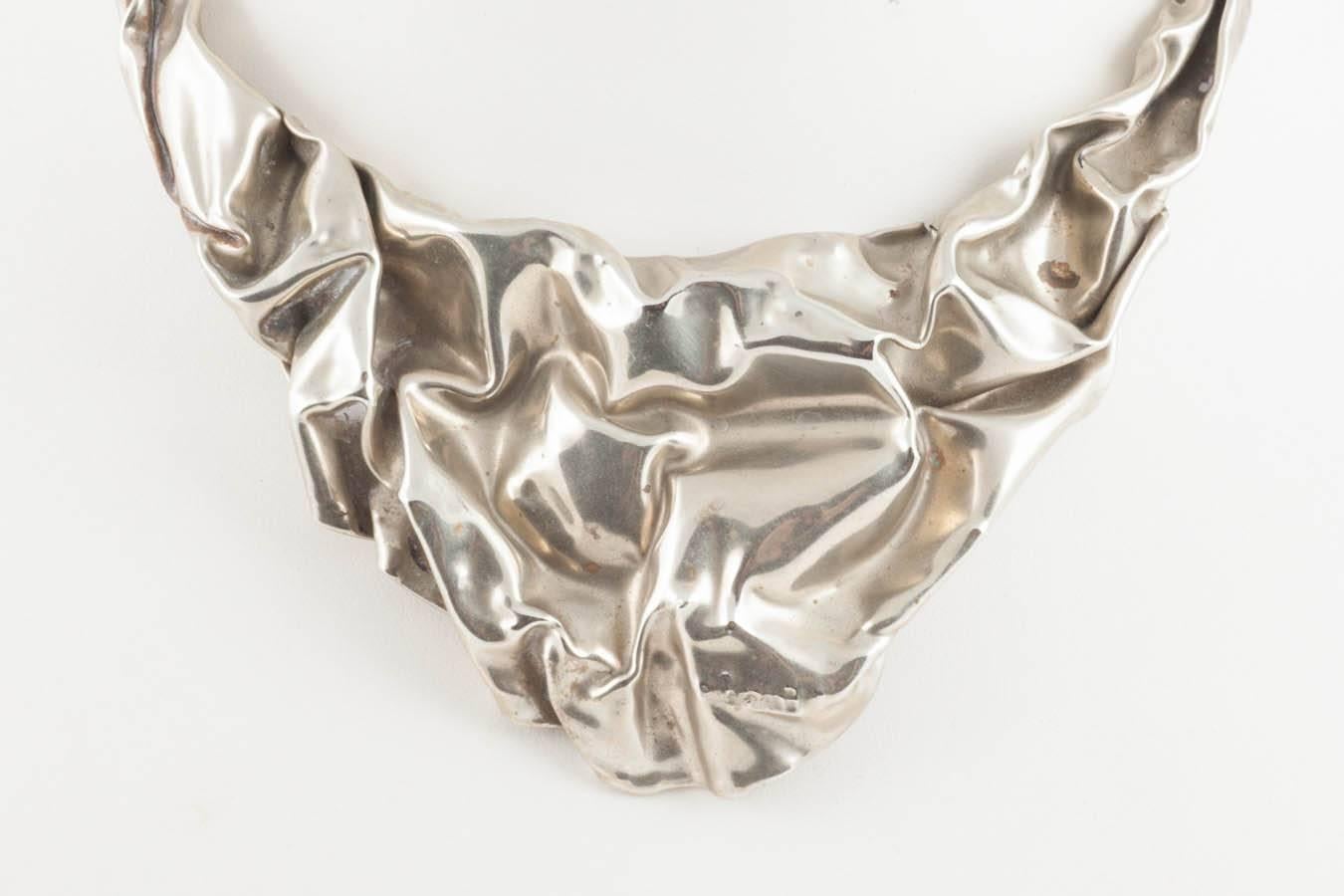 Wonderful designer maker 'crumpled paper' style silver tone metal necklace. It looks so modern and intriguing. It is also very light which makes it very easy to wear. Sadly the signature is completely illegible. Nevertheless, a great modernist
