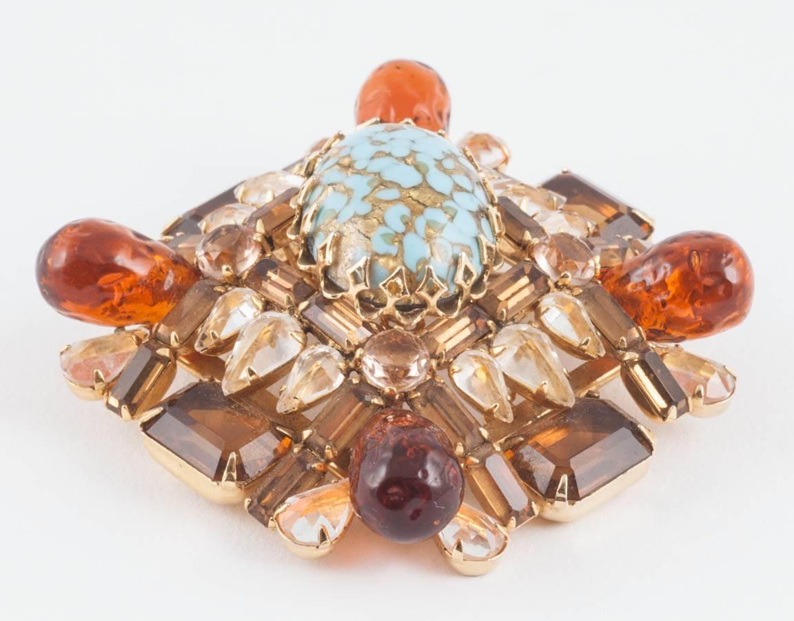 This is a show stopping brooch although unsigned can be attributed to Henry Schreiner. The unusual colour palette, multi shaped stones set the 'wrong way up' and large claw settings clearly stamp it as a couture piece by this designer. These were